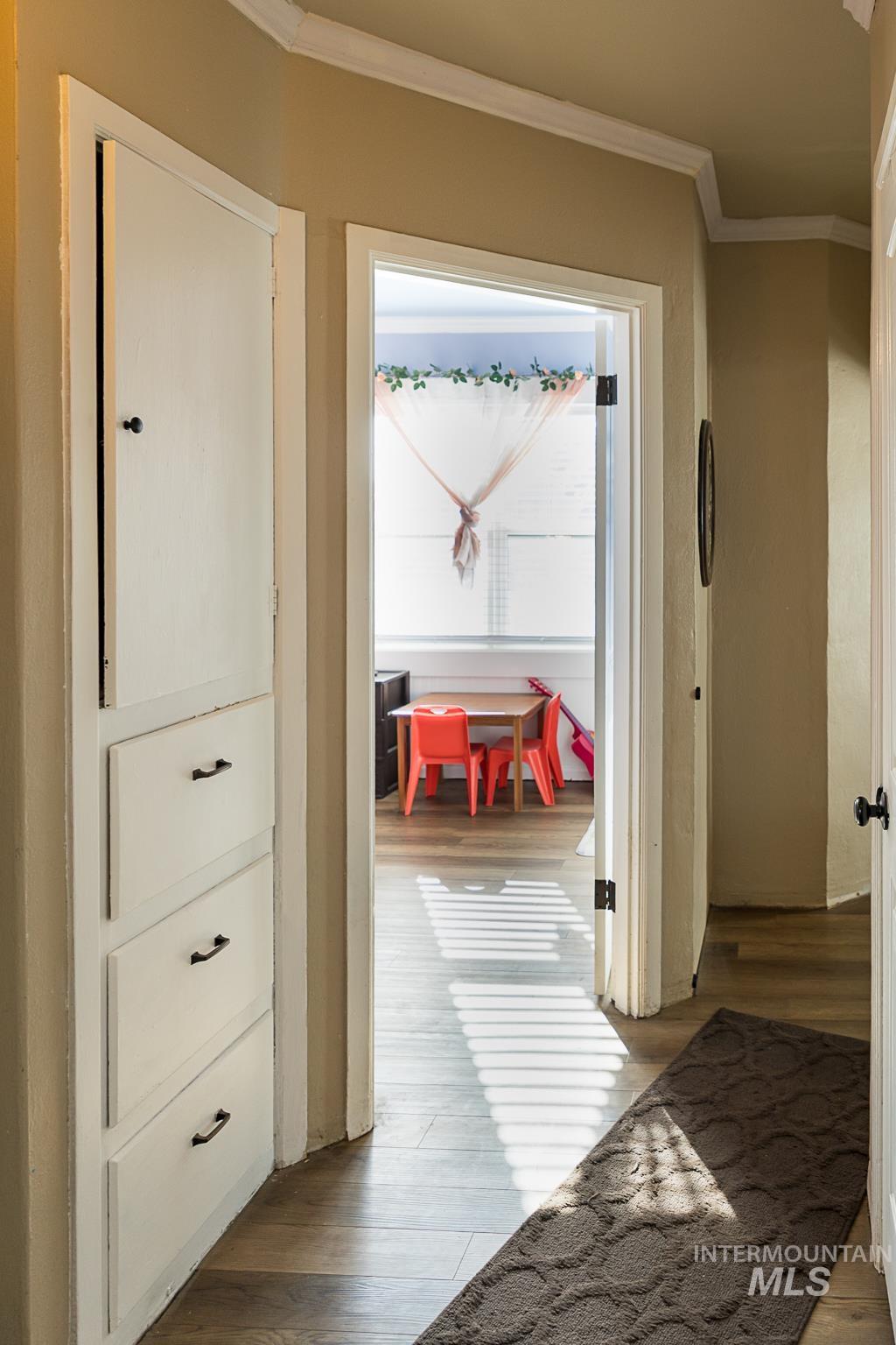 Hallway featuring light wood-style floors and crown molding