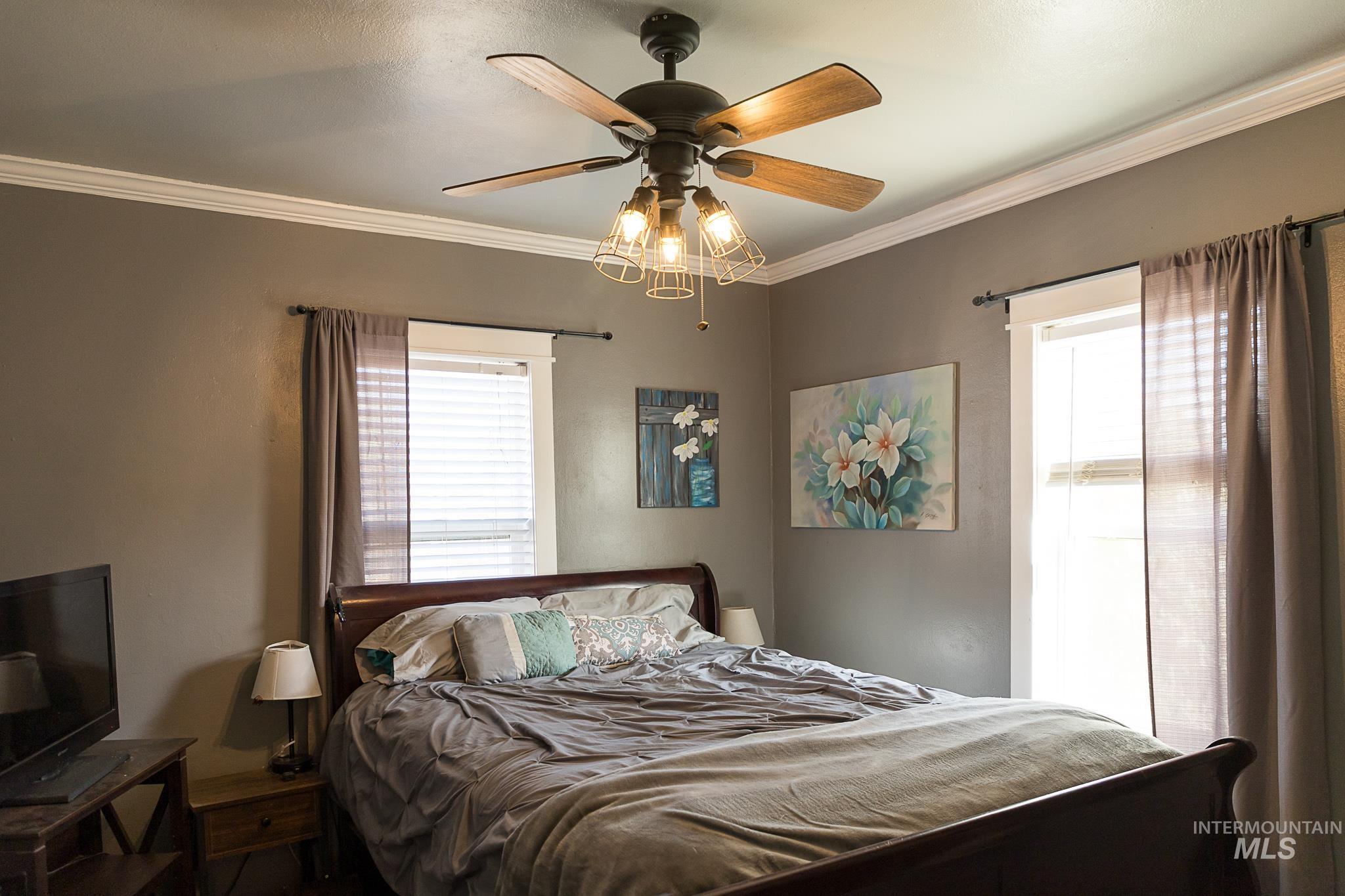 Bedroom with crown molding and a ceiling fan