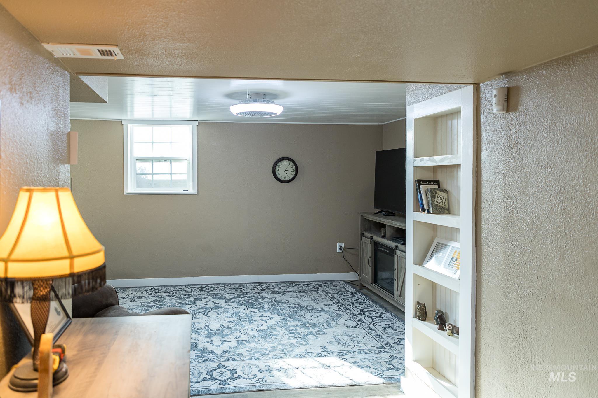 Living area featuring a textured wall, a textured ceiling, and built in shelves