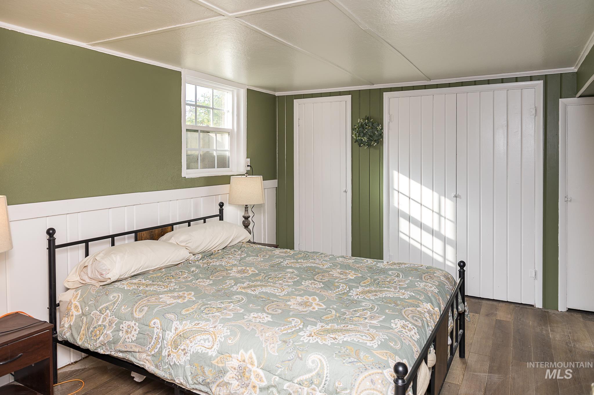 Bedroom with dark wood-type flooring and a closet