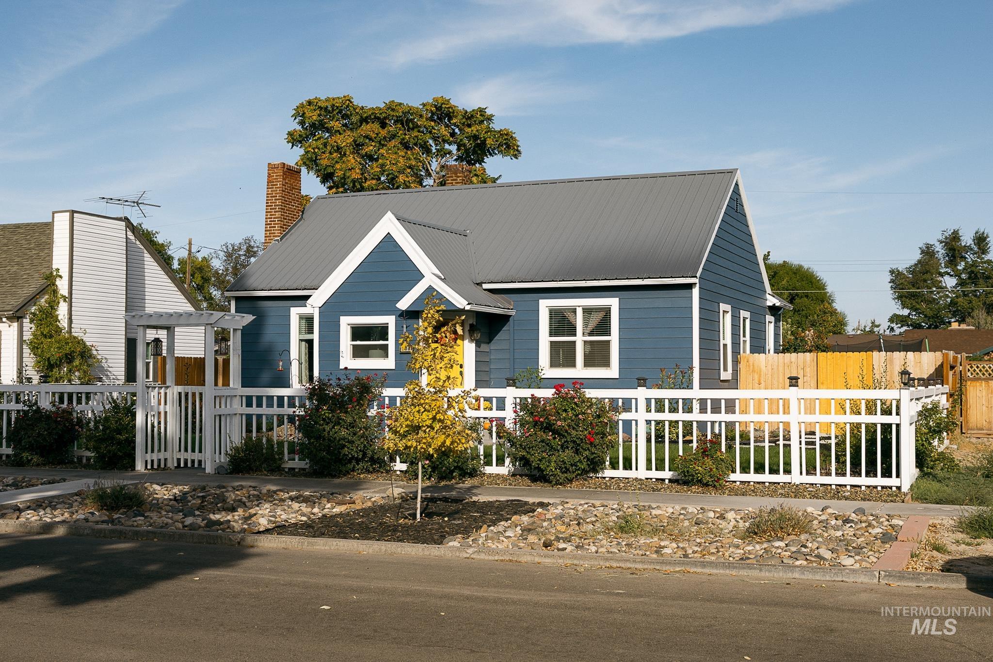 View of front facade with a metal roof and a chimney