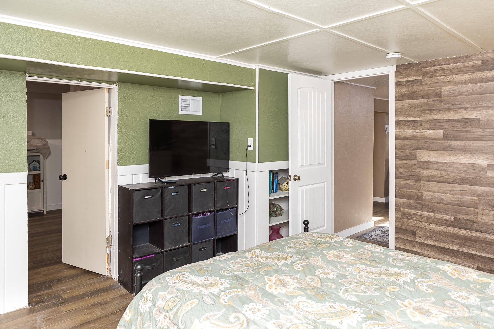 Bedroom with dark wood-style flooring and wooden walls