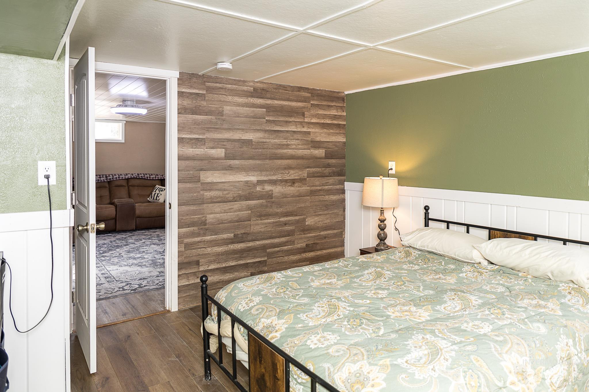 Bedroom featuring dark wood finished floors and wood walls