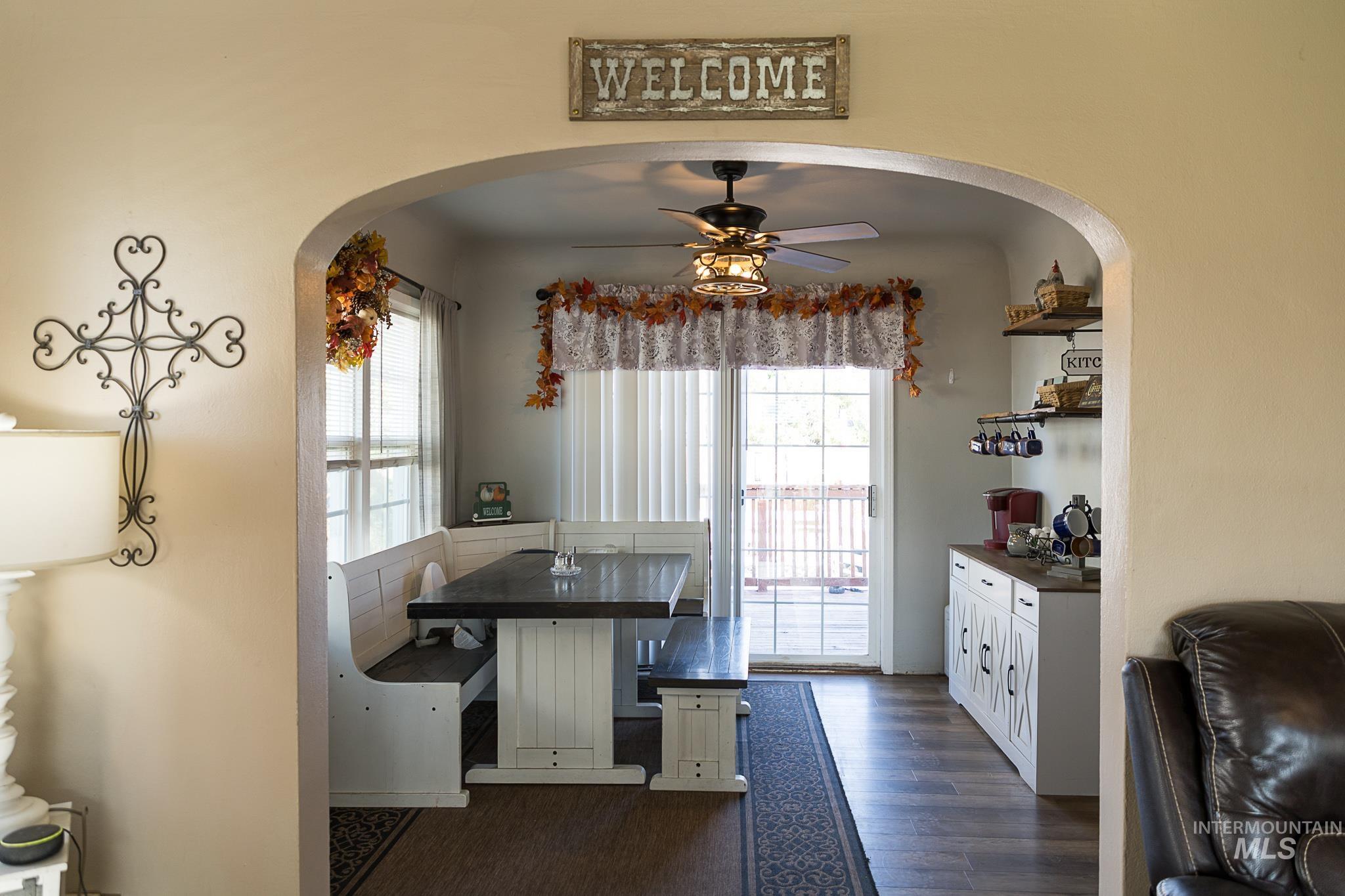 Dining area featuring arched walkways, a ceiling fan, healthy amount of natural light, and dark wood finished floors