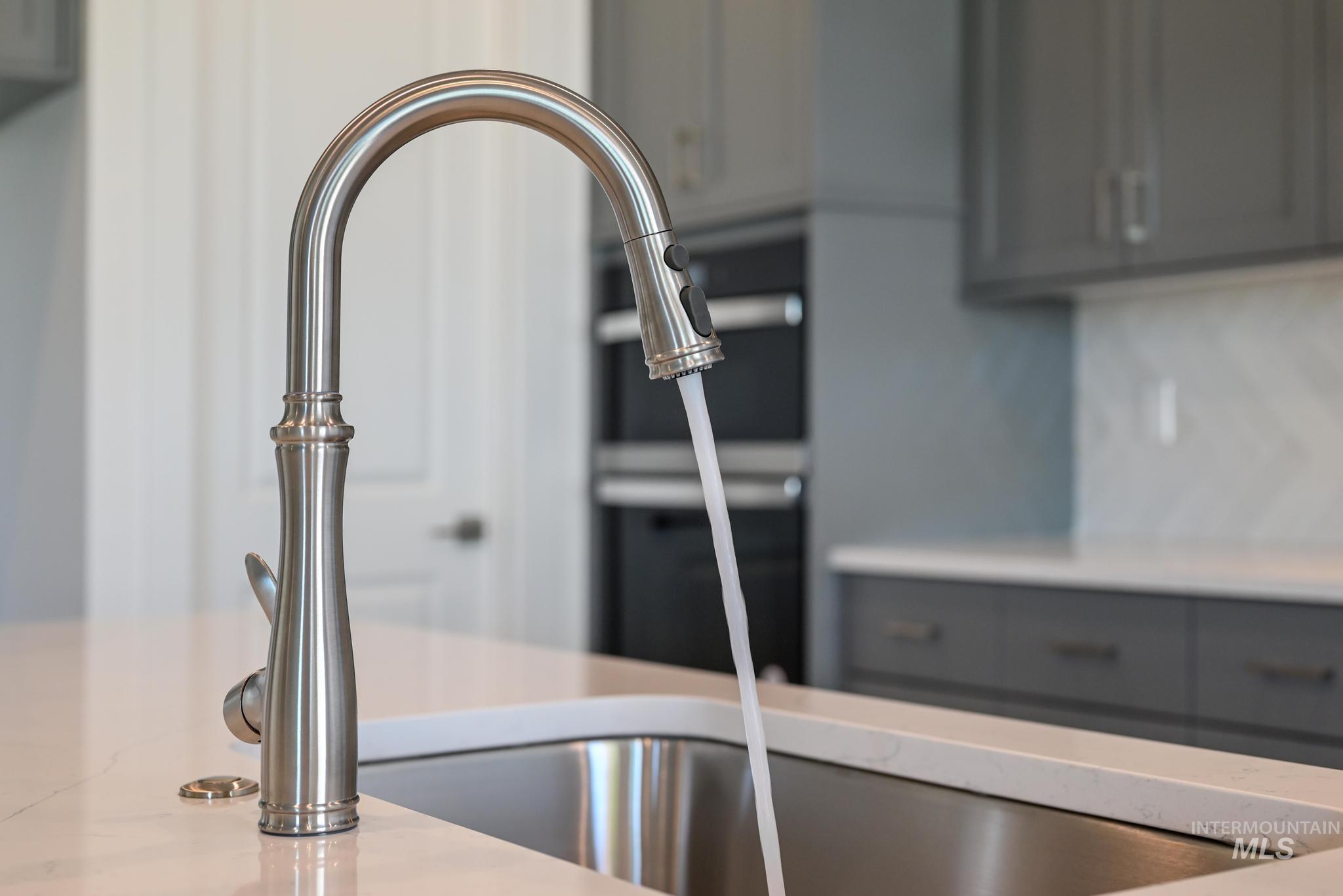 Kitchen view of gray cabinetry and a sink