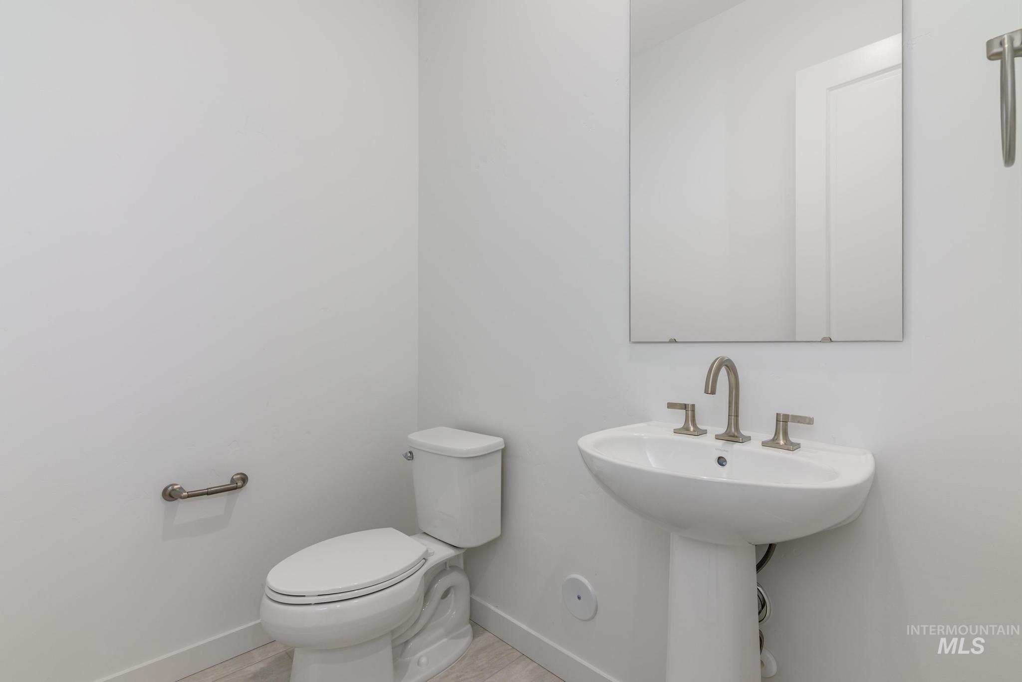 Half bath featuring baseboards and light wood-style flooring