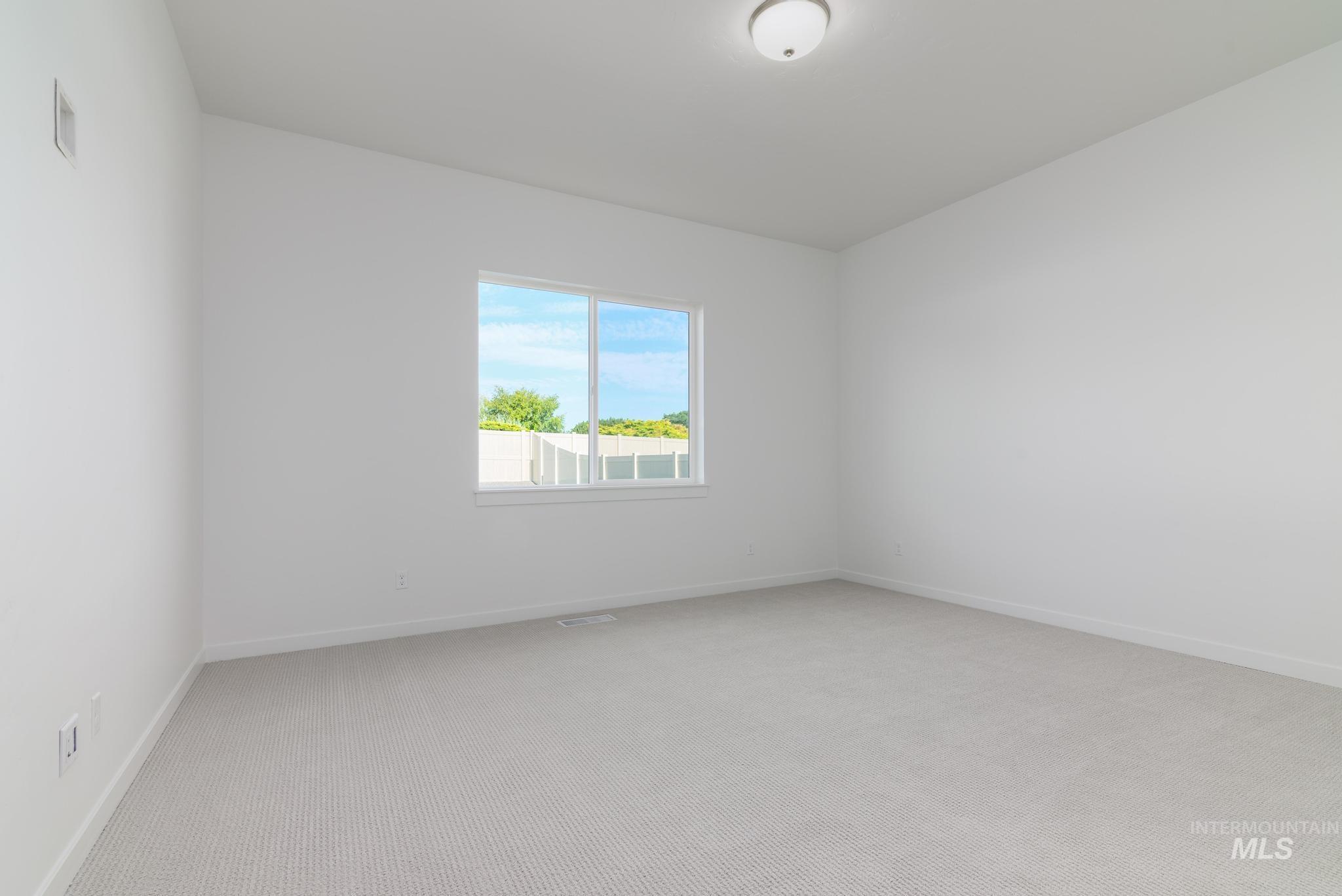 Empty room with light colored carpet