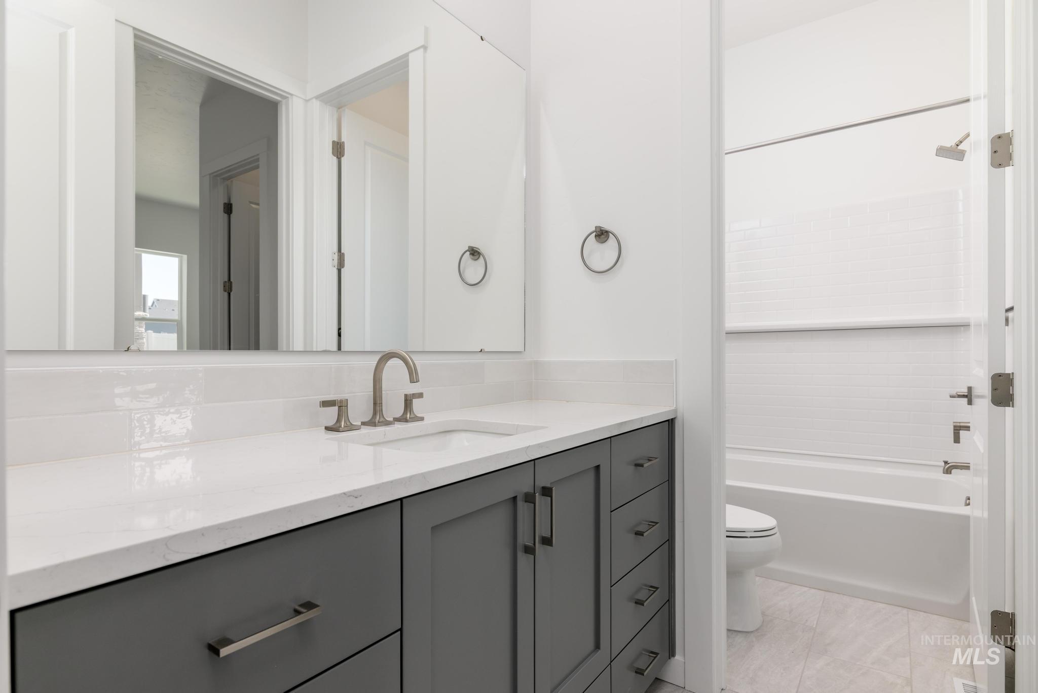 Bathroom featuring vanity, bathtub / shower combination, and light tile patterned floors