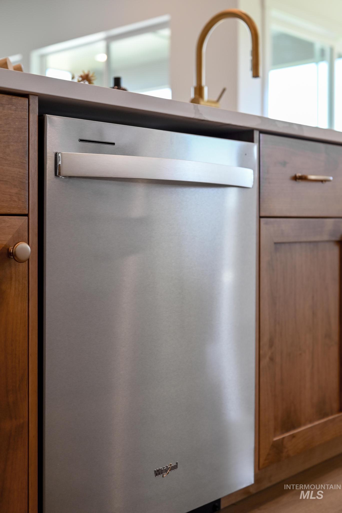 Kitchen view of dishwasher and brown cabinets