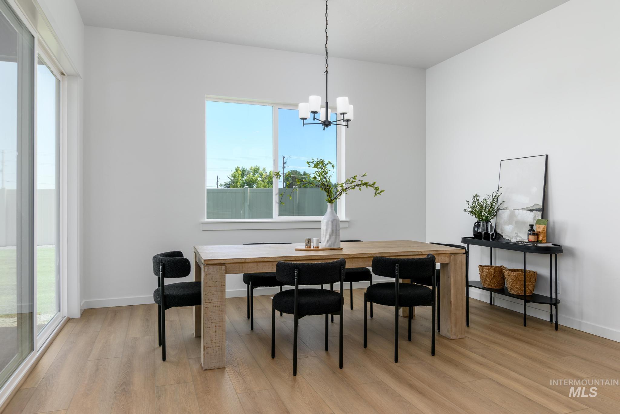 Dining room with light wood-style flooring and a chandelier