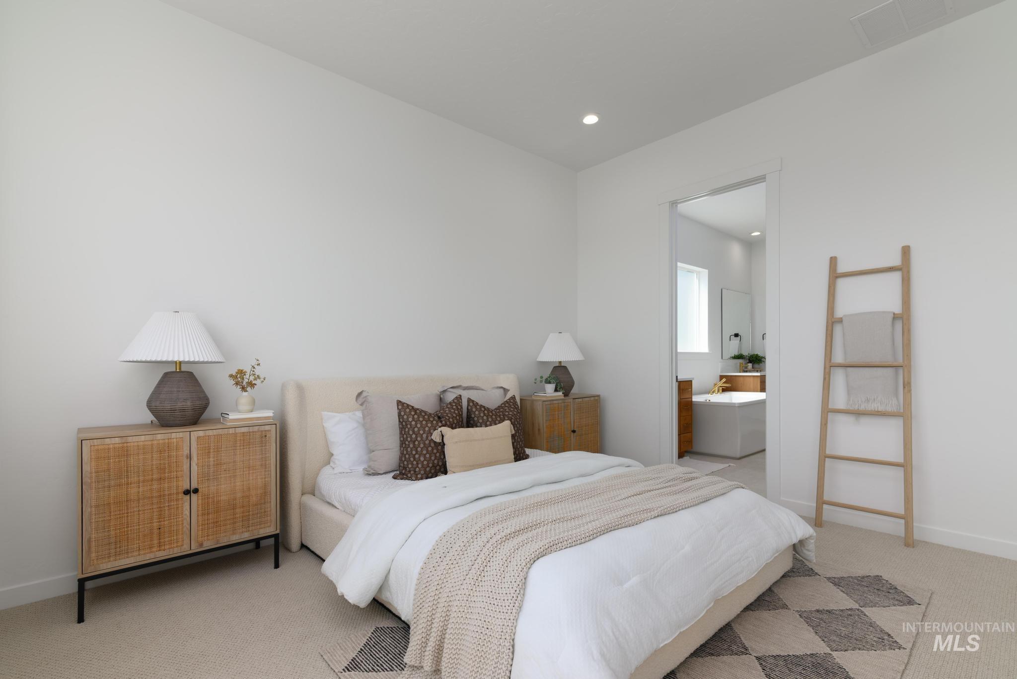 Bedroom featuring light carpet, recessed lighting, and connected bathroom