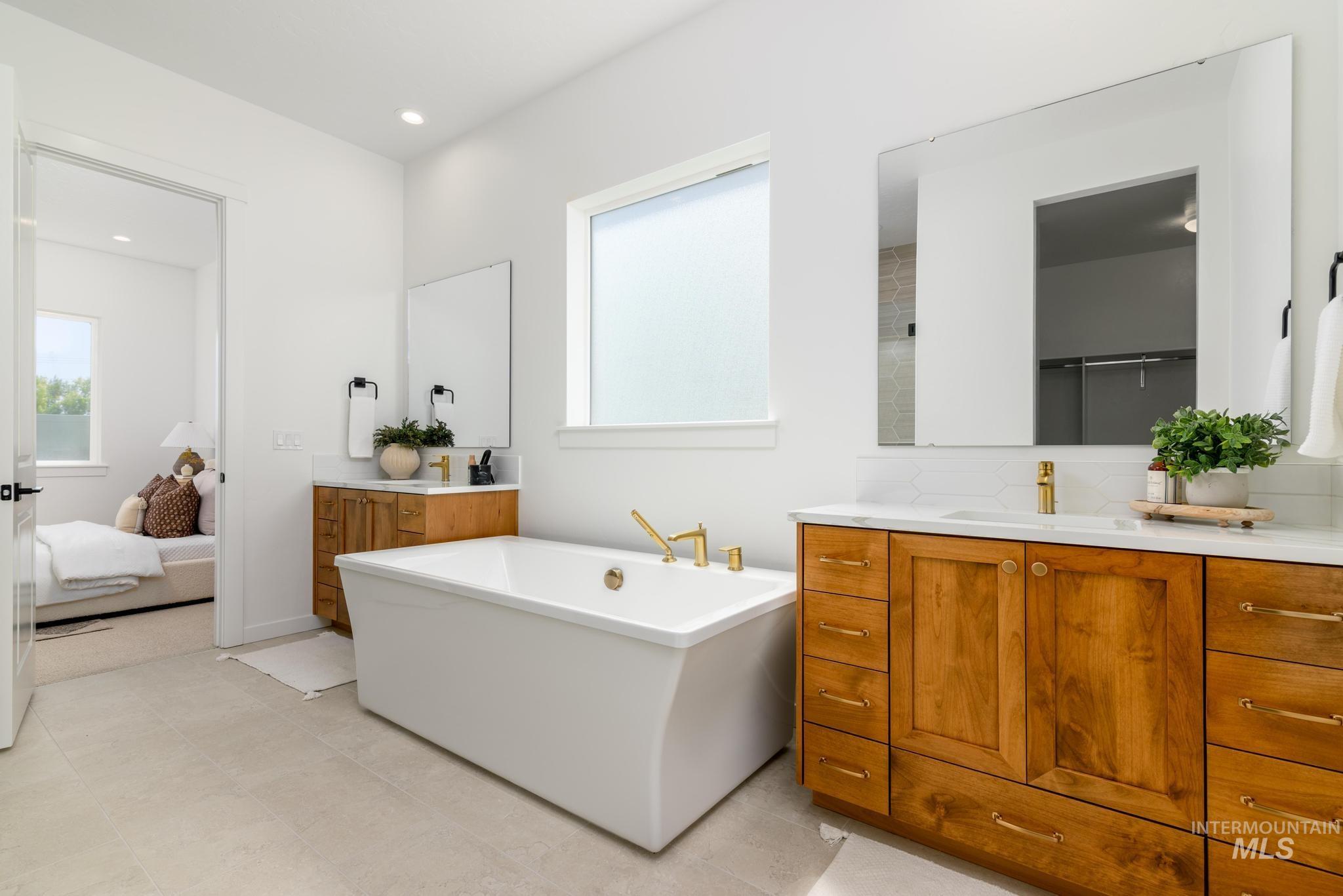 Bathroom with plenty of natural light, a freestanding bath, vanity, ensuite bath, and recessed lighting