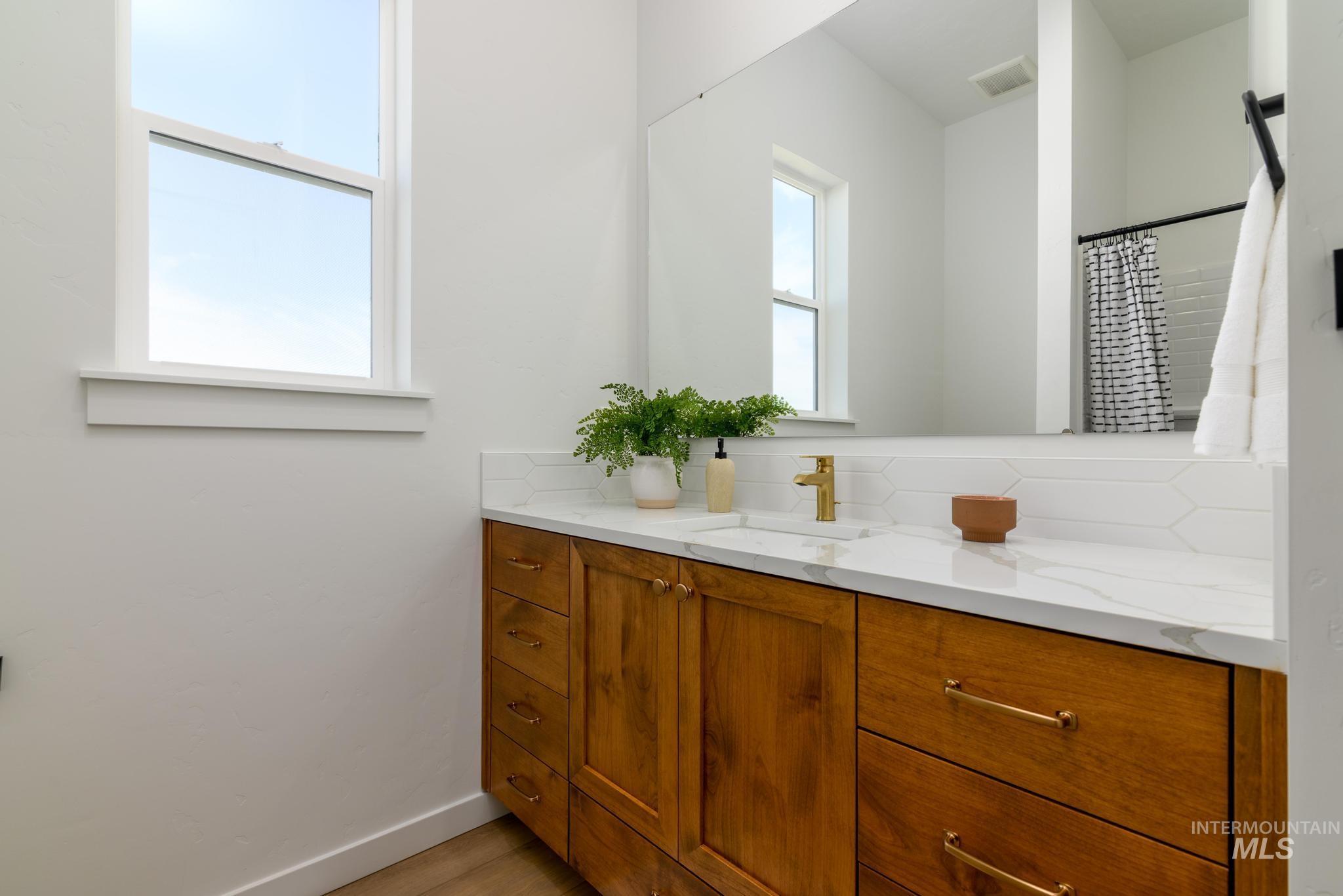 Full bathroom with vanity and curtained shower