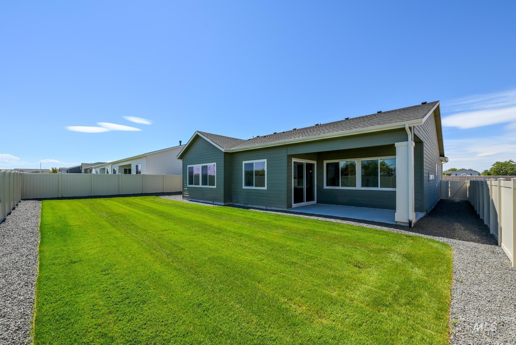 Rear view of house with a fenced backyard, a patio area, and a shingled roof