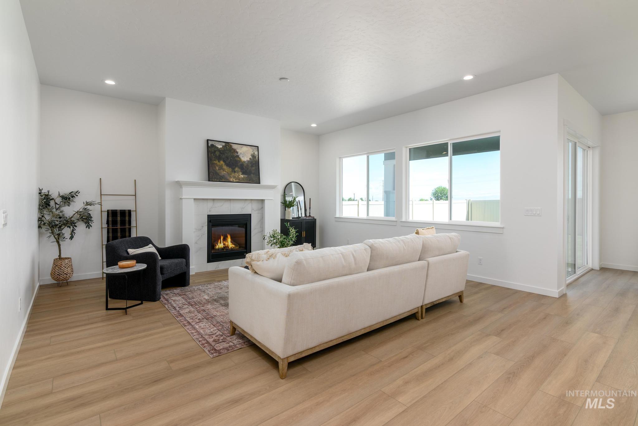 Living area with a fireplace, light wood finished floors, and recessed lighting