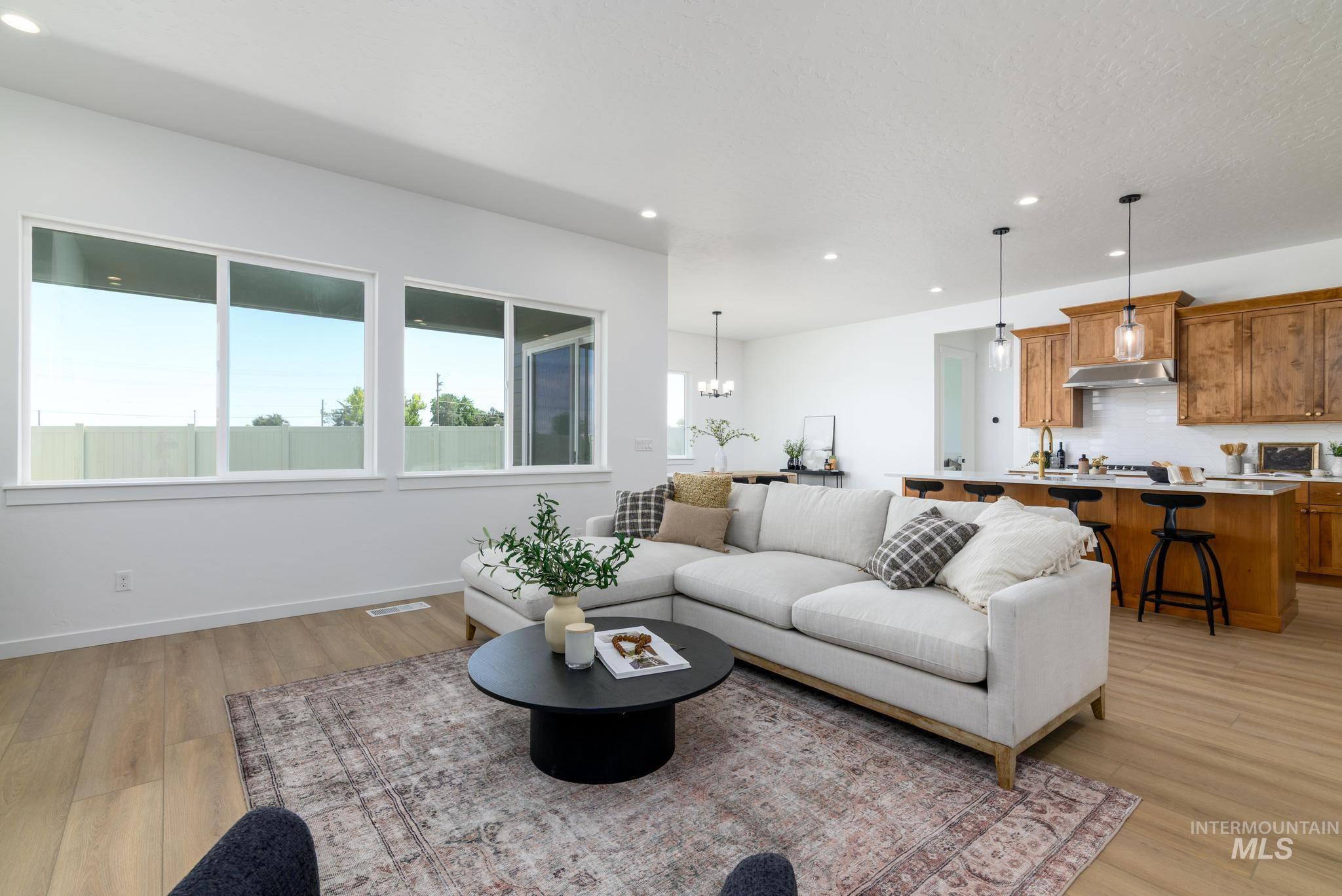Living room featuring recessed lighting, a chandelier, and light wood-type flooring