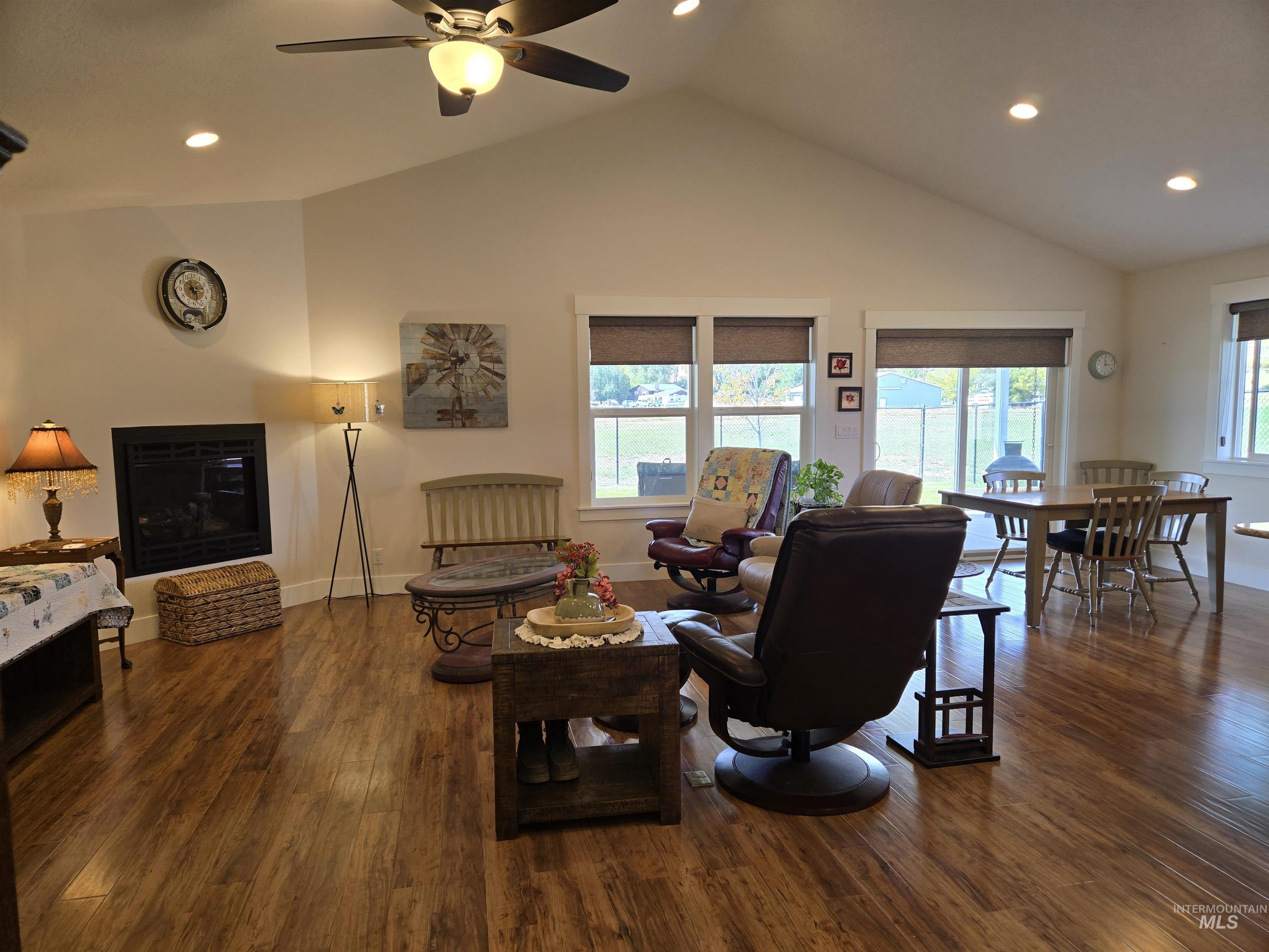Living room with recessed lighting, dark wood-style flooring, a ceiling fan, and high vaulted ceiling