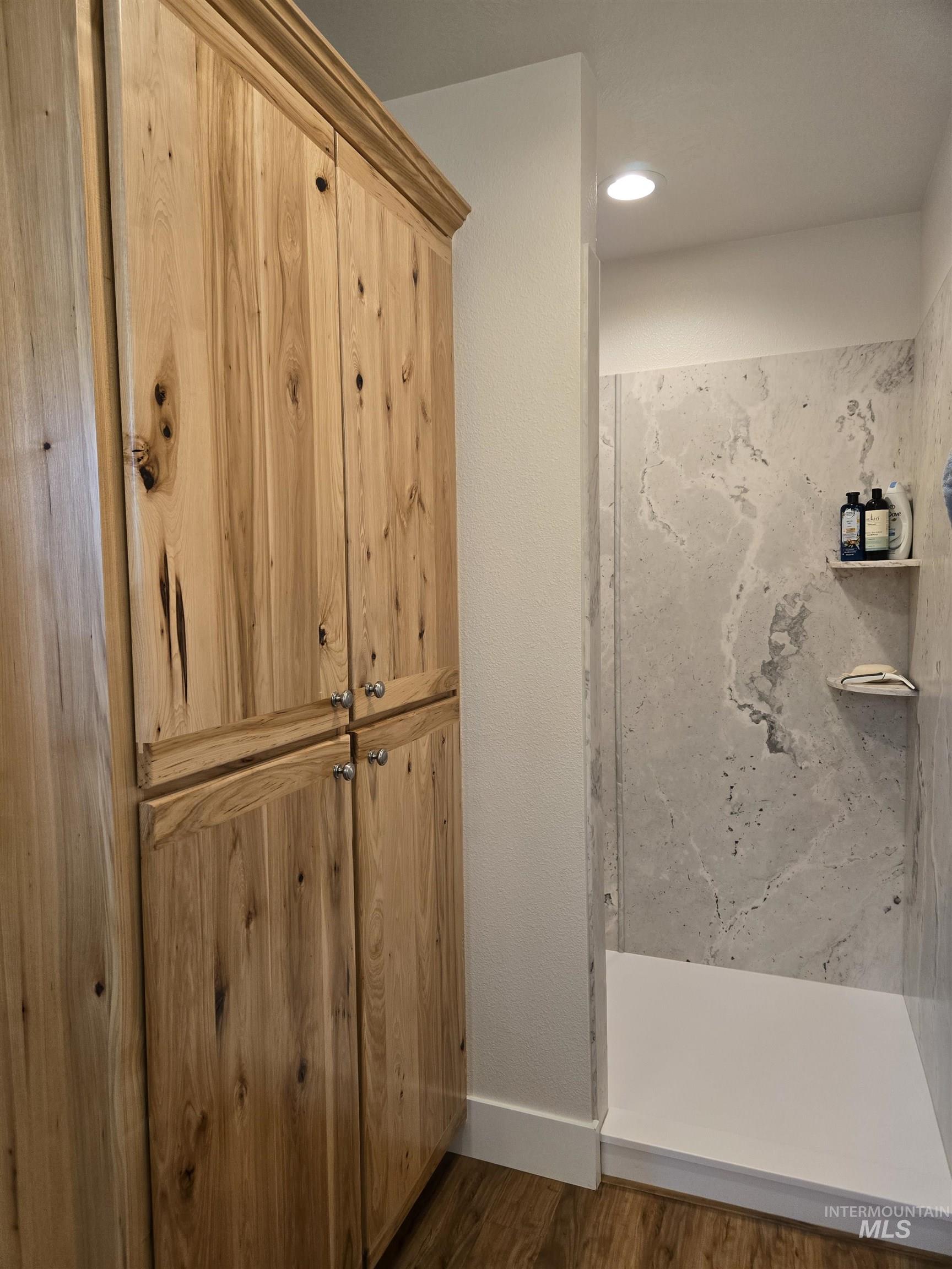 Full bath with dark wood-style flooring and a walk in shower