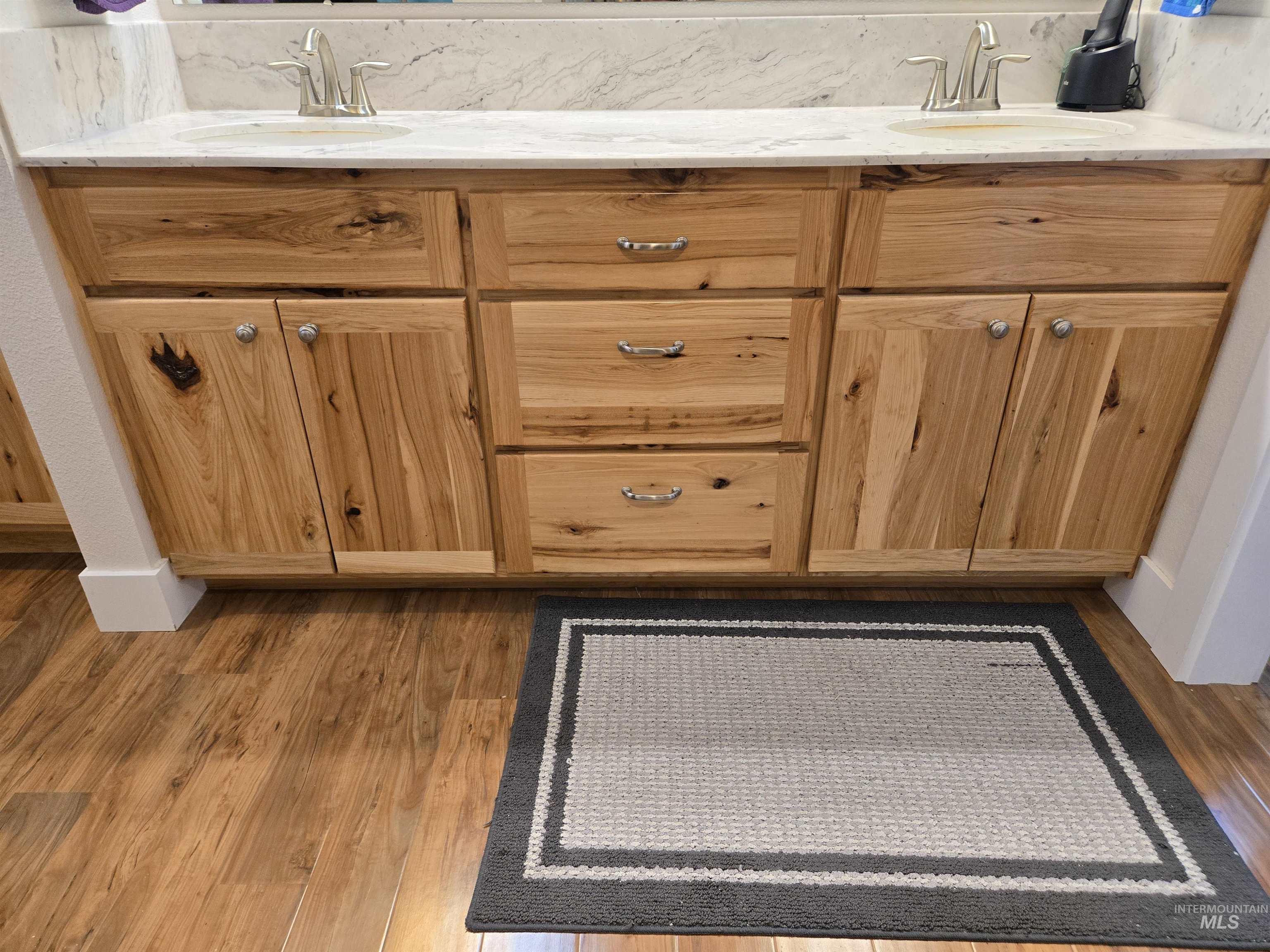 Bathroom view of double vanity and wood finished floors