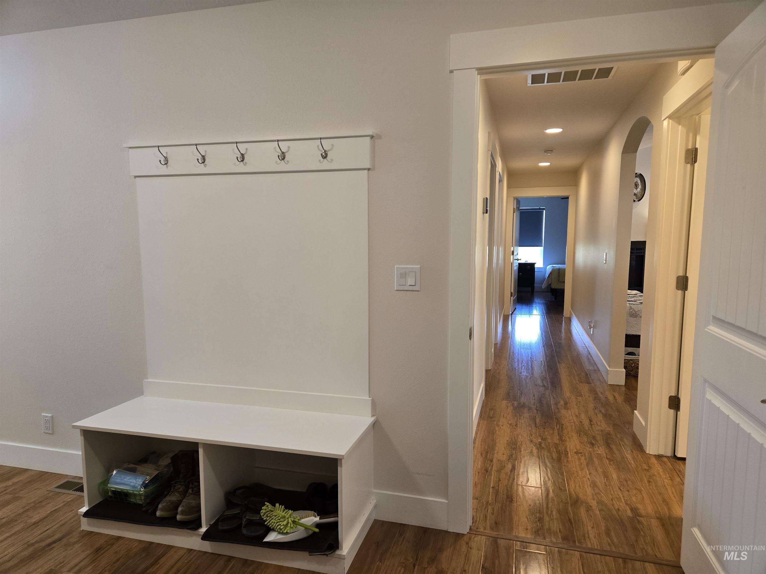 Mudroom with dark wood-type flooring, arched walkways, and recessed lighting