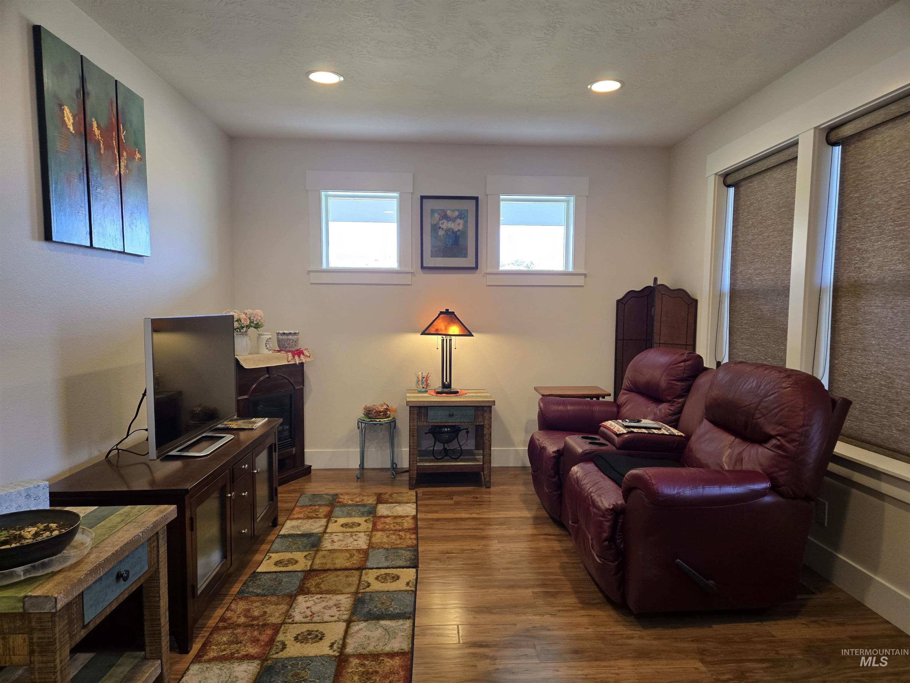 Sitting room with wood finished floors and recessed lighting