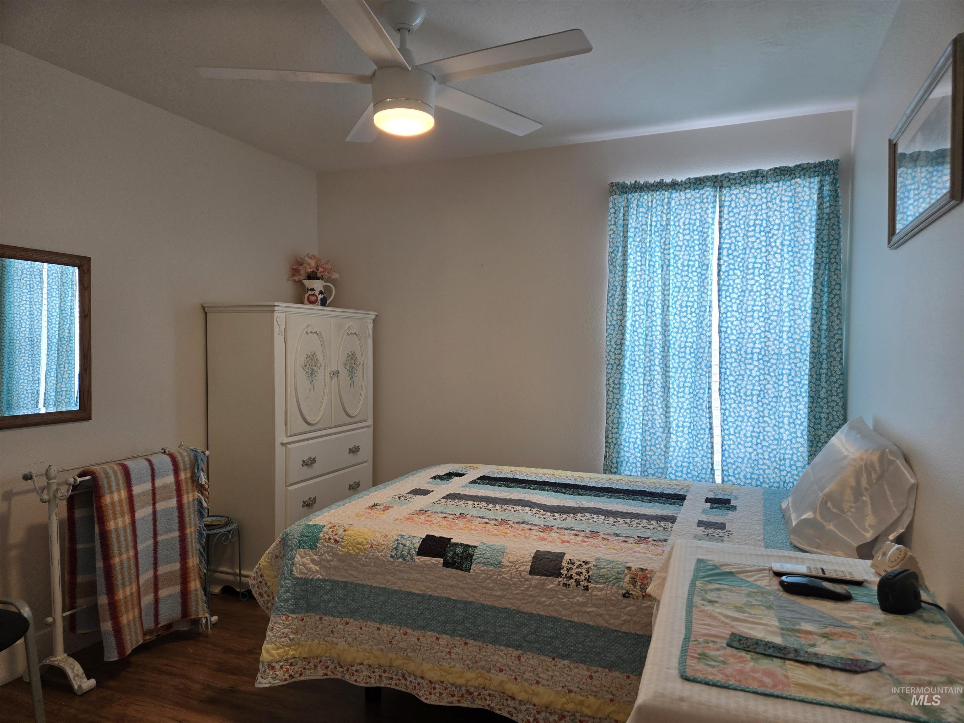 Bedroom with dark wood-style flooring and ceiling fan