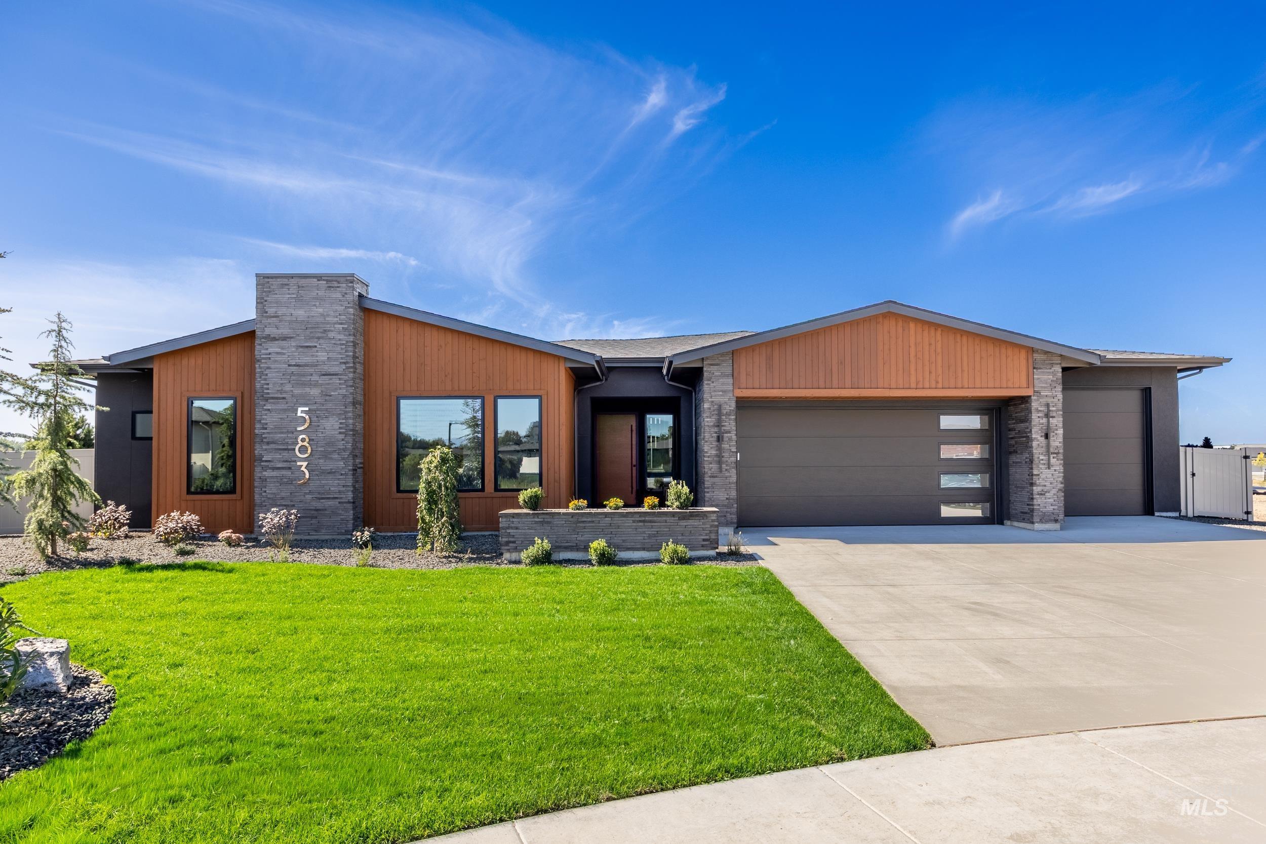 View of front of house with a garage, driveway, and a front yard