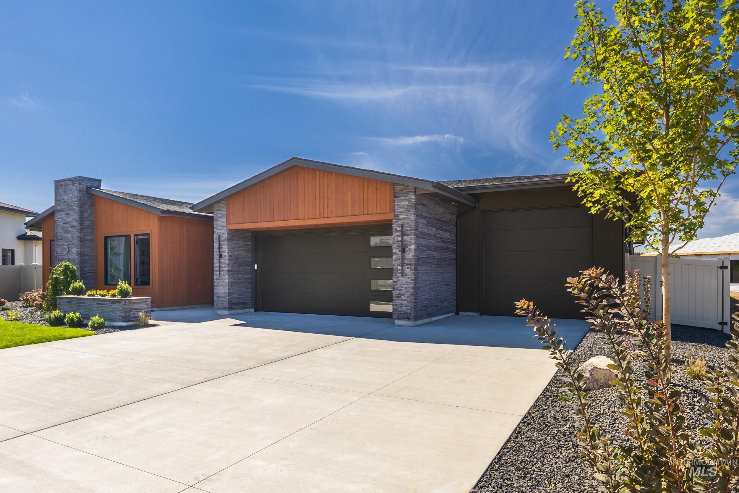 Modern home with concrete driveway and an attached garage