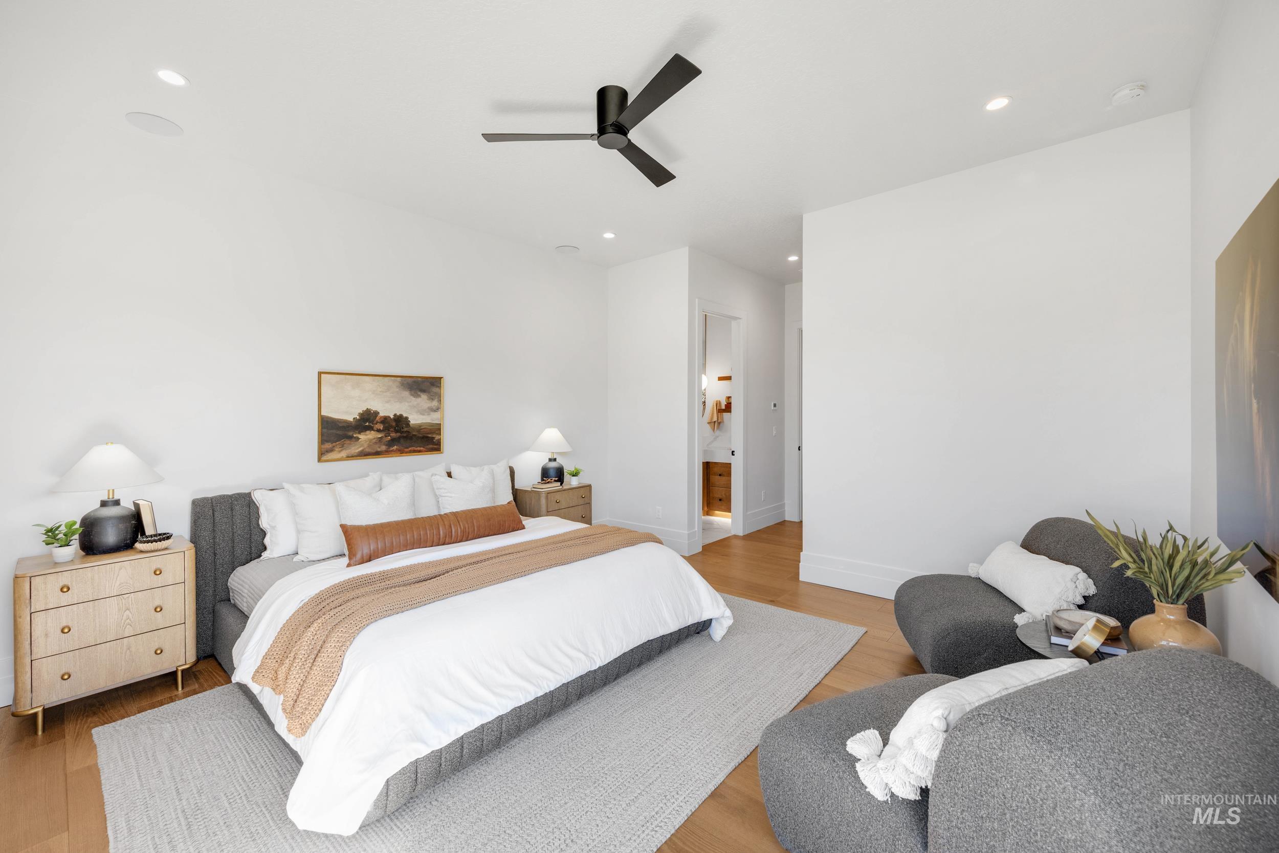 Bedroom with light wood-type flooring, recessed lighting, a ceiling fan, and connected bathroom