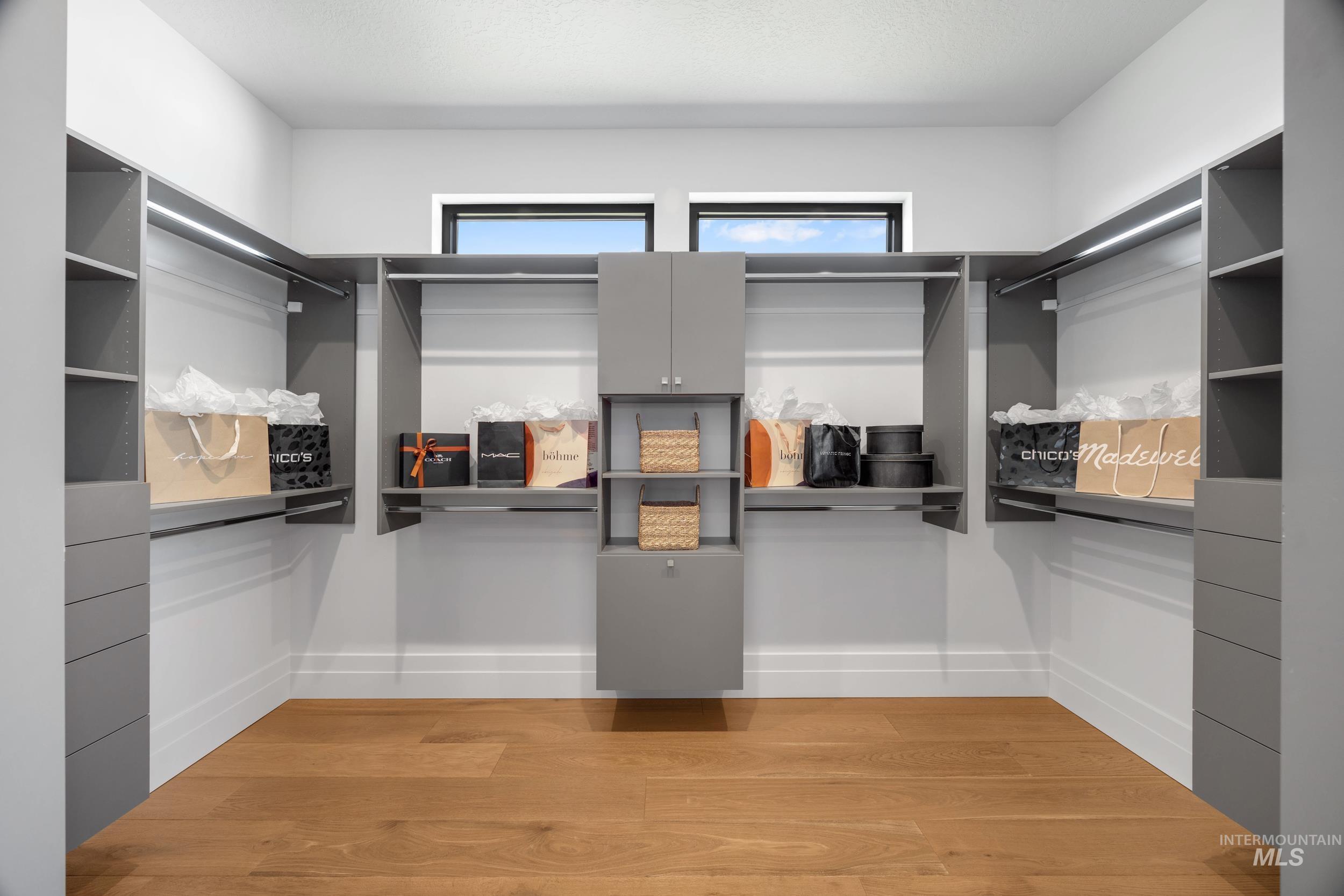 Walk in closet with light wood-type flooring
