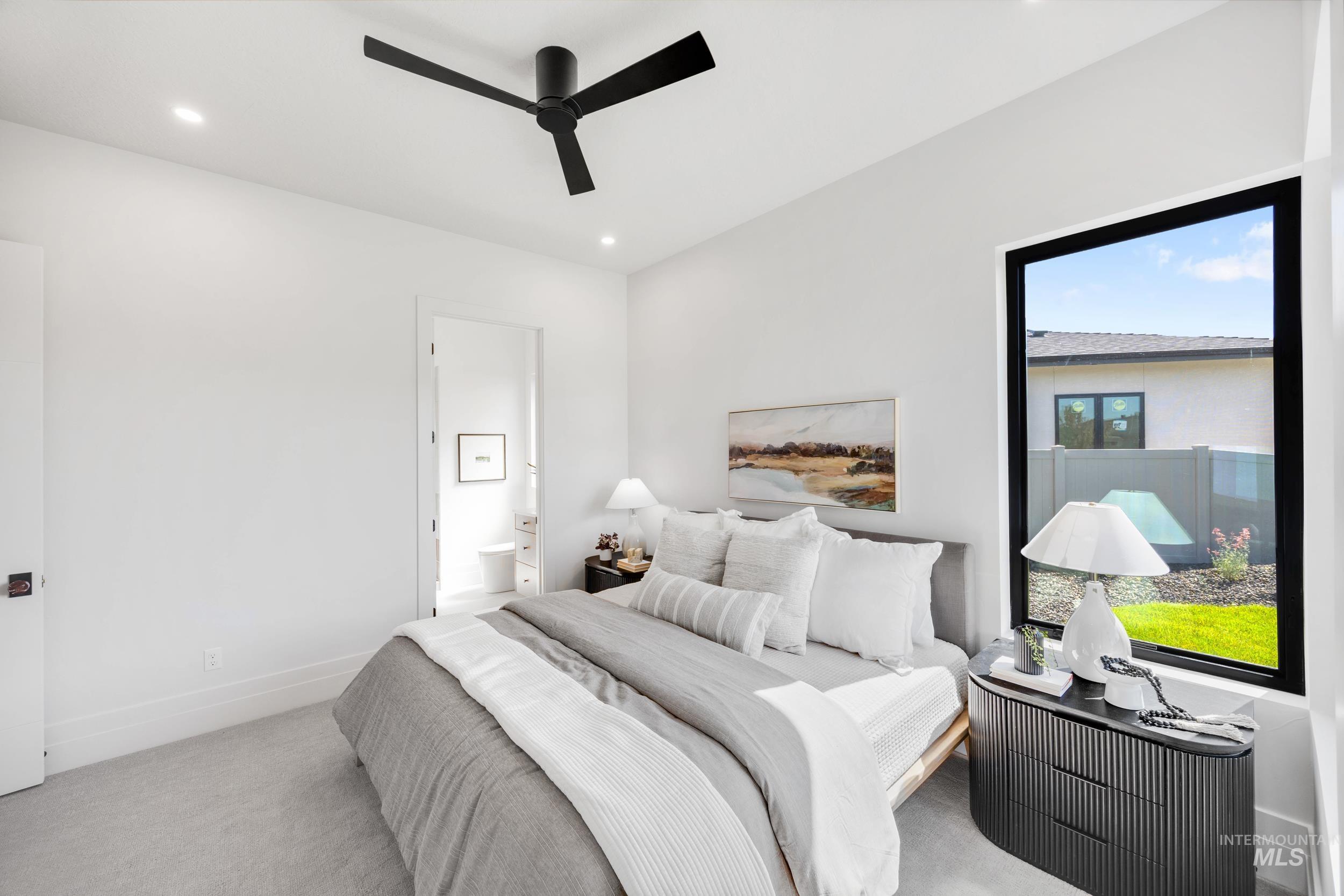 Carpeted bedroom with recessed lighting, ceiling fan, and ensuite bathroom