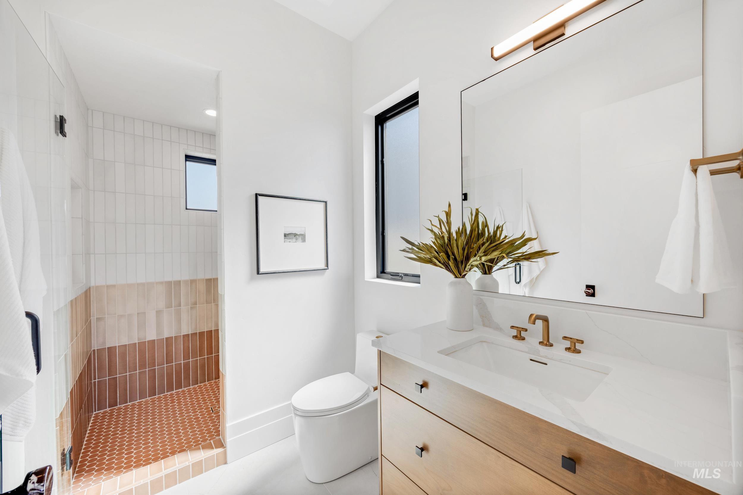 Bathroom with vanity, walk in shower, and light tile patterned floors