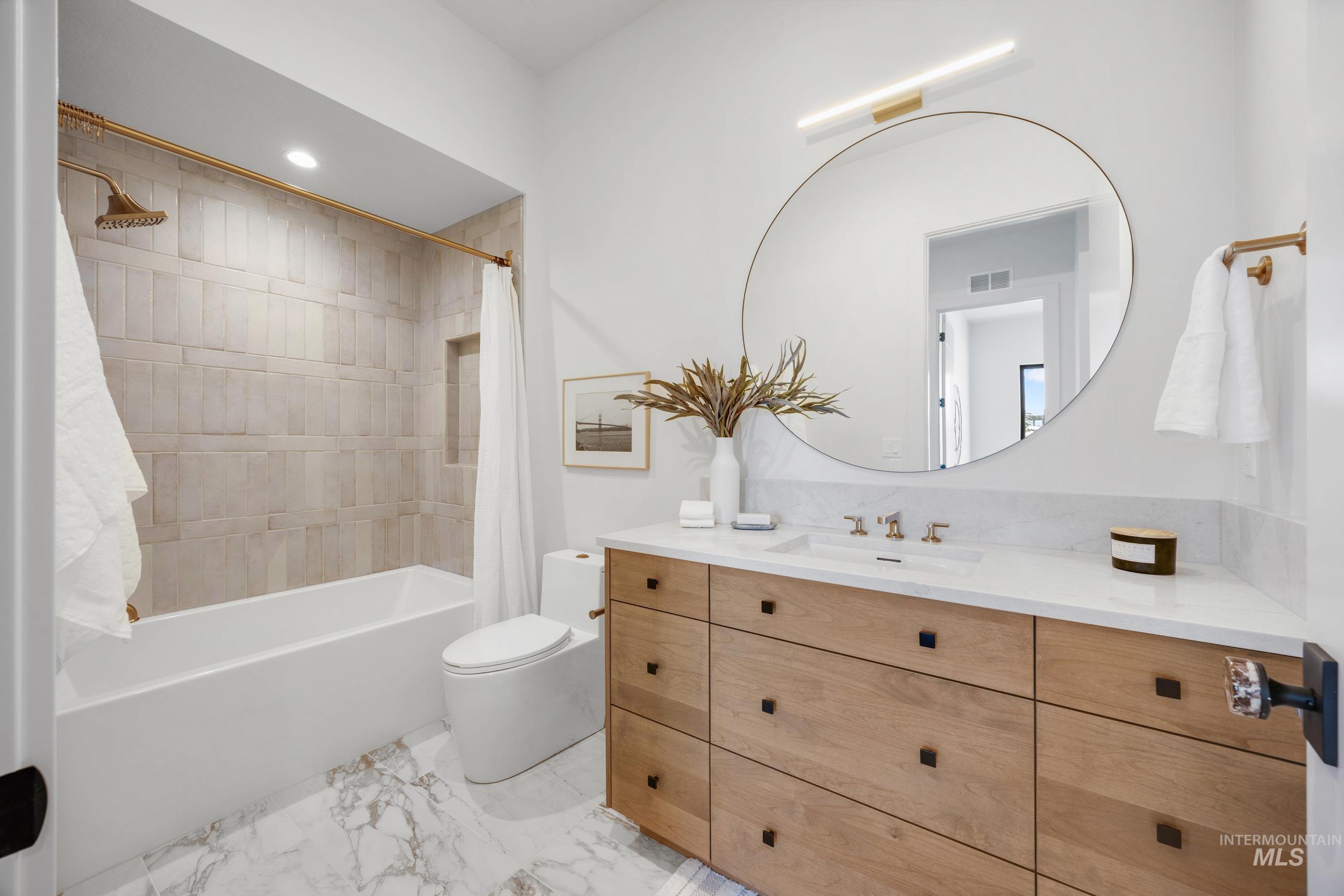 Bathroom featuring shower / bathtub combination with curtain, recessed lighting, vanity, and light marble finish flooring