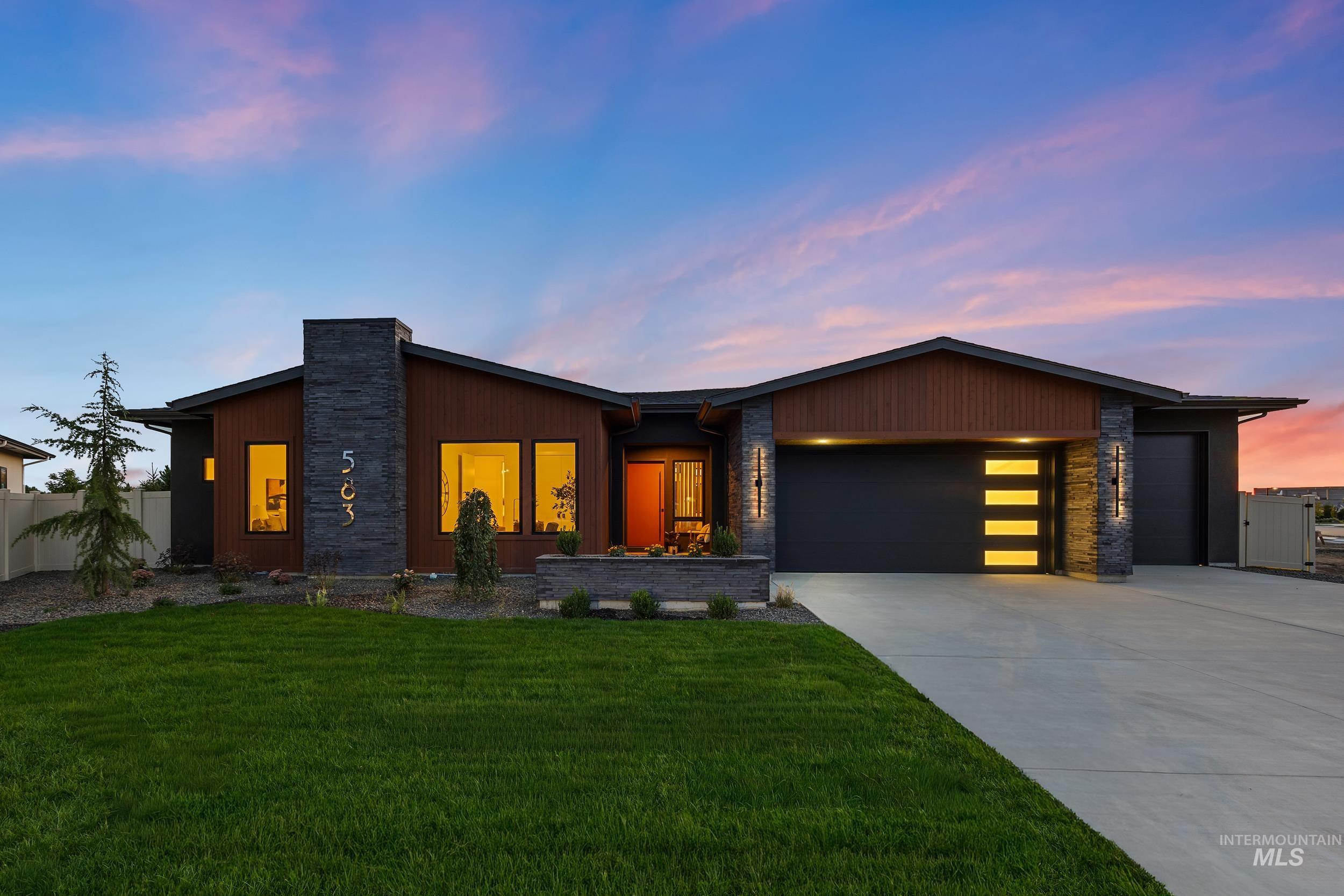 Contemporary house with a garage, driveway, and stone siding