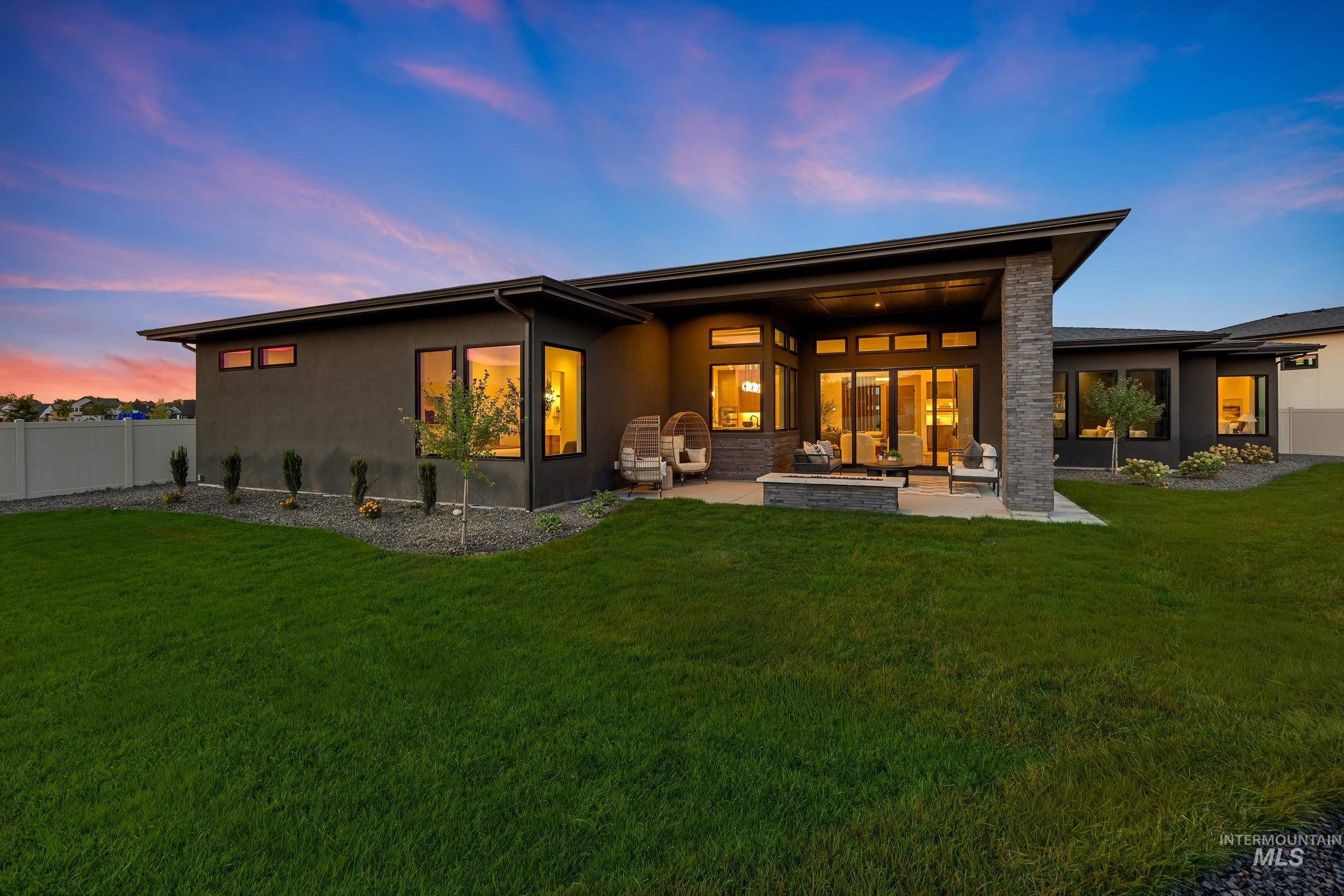 Rear view of house with a patio, stucco siding, and an outdoor living space with a fire pit