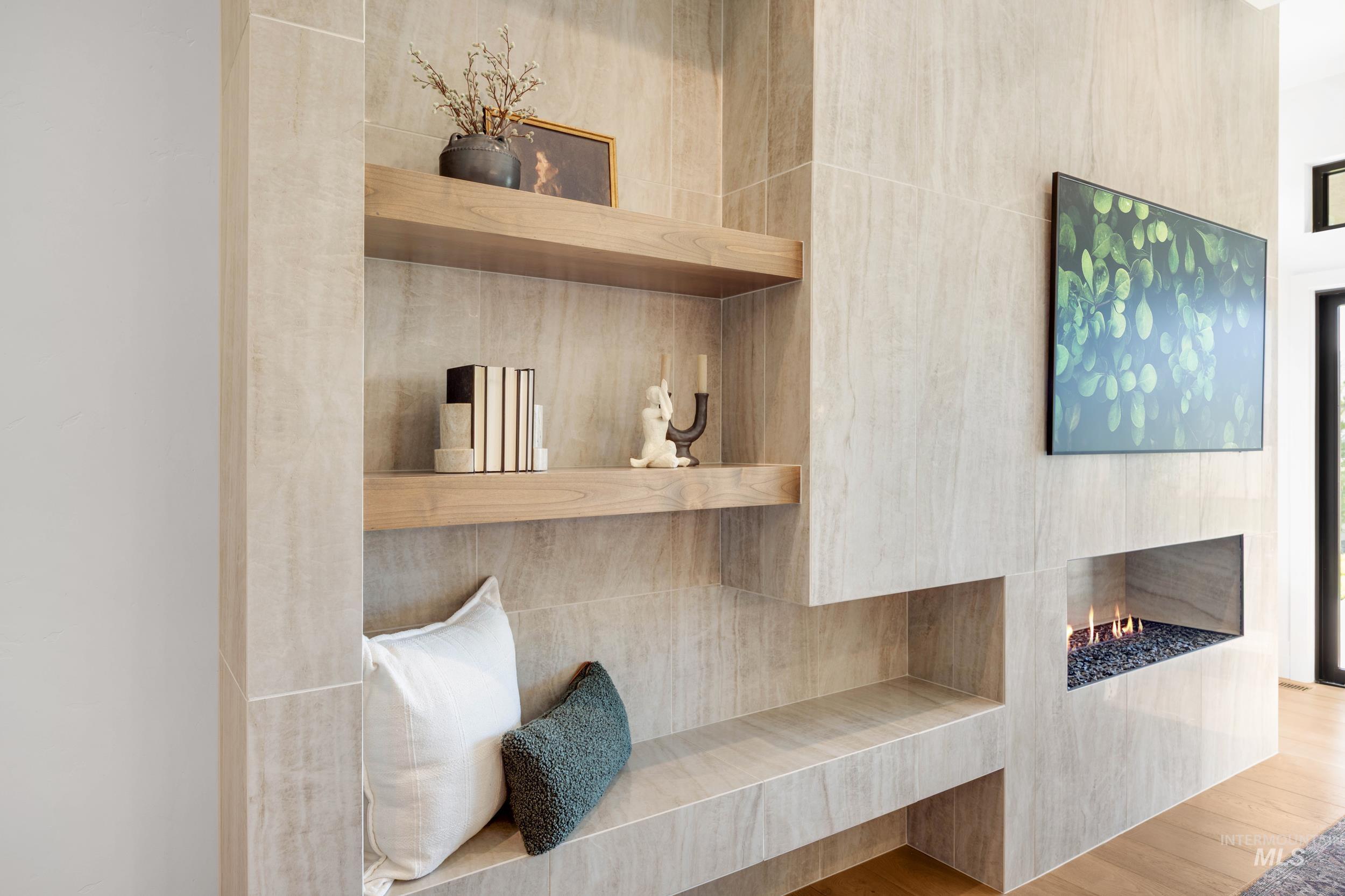 Detailed view of wood finished floors, tile walls, and a lit fireplace