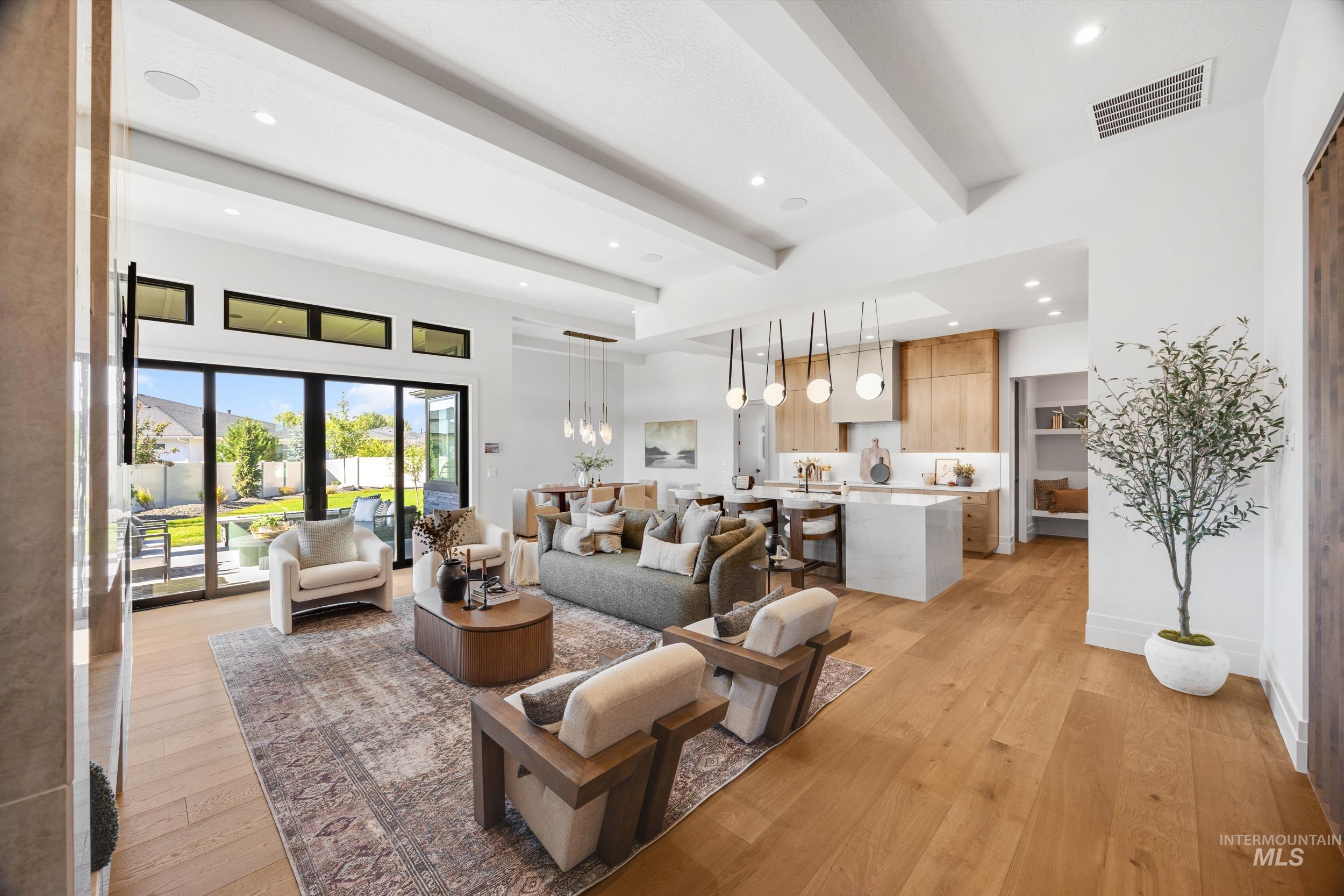 Living room featuring beamed ceiling, light wood finished floors, and recessed lighting