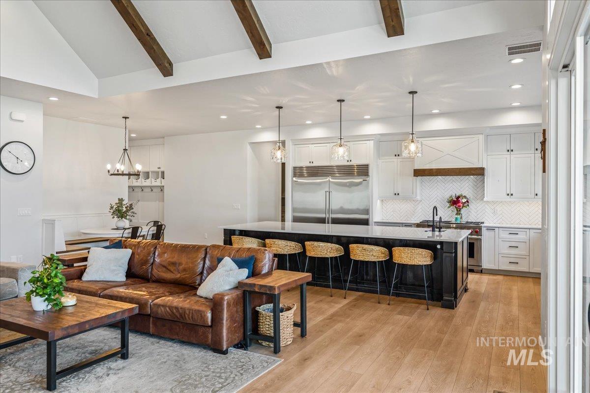 Living room featuring recessed lighting, light wood-style floors, and a chandelier