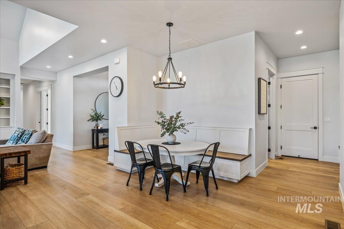 Dining room with recessed lighting, light wood-style floors, and a chandelier