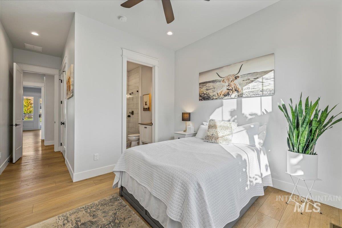Bedroom featuring light wood finished floors, recessed lighting, ceiling fan, and connected bathroom