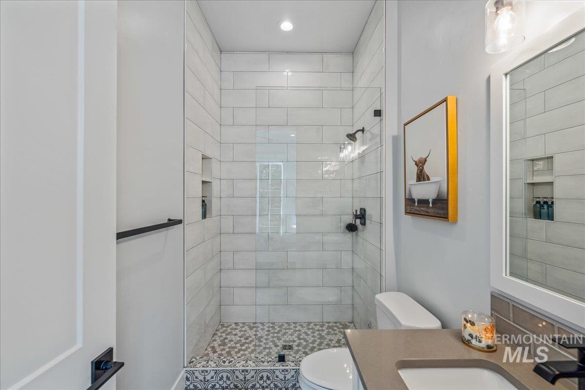 Bathroom with walk in shower, vanity, and recessed lighting