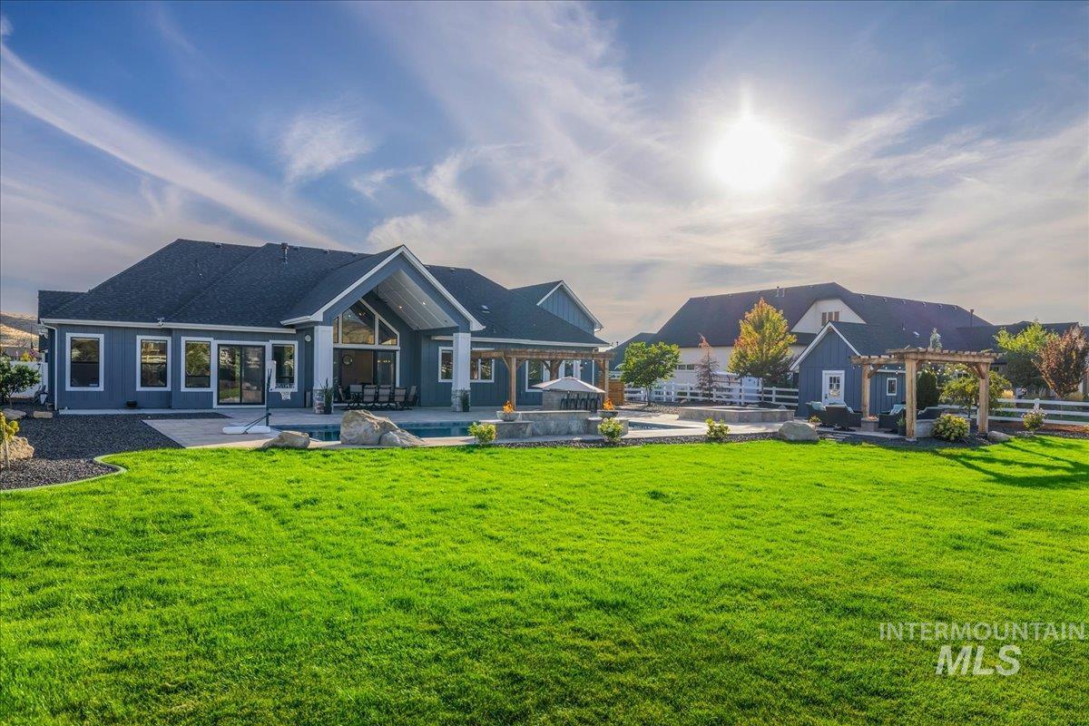 Back of property featuring a patio area, a pool, and a yard