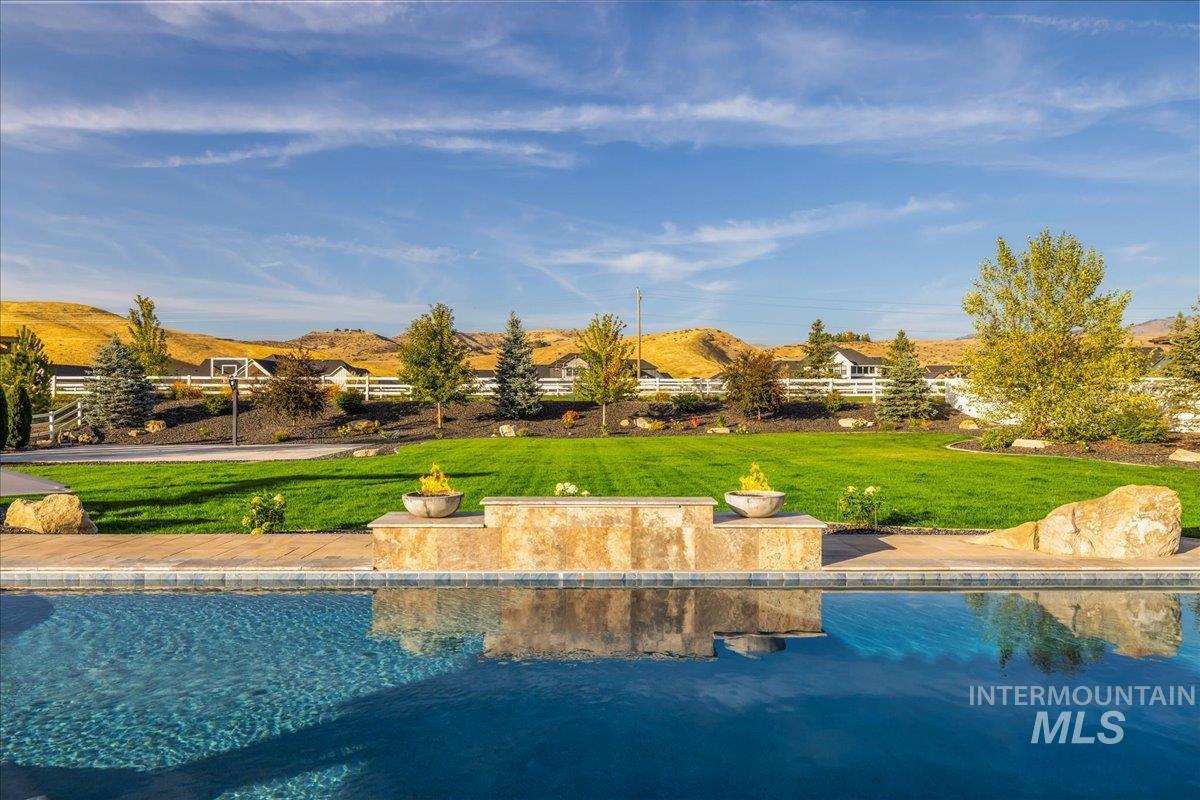 Outdoor pool featuring a lawn and a mountain view