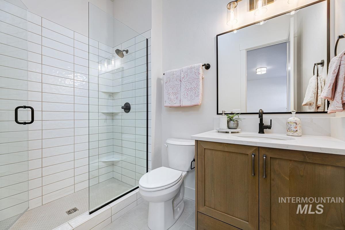 Bathroom with a shower stall, vanity, and light tile patterned floors