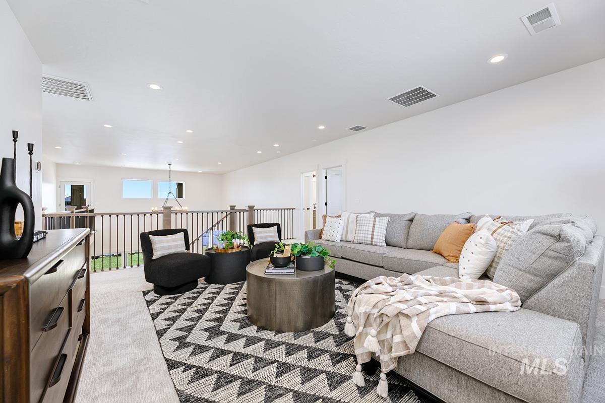 Carpeted living room with recessed lighting and a chandelier