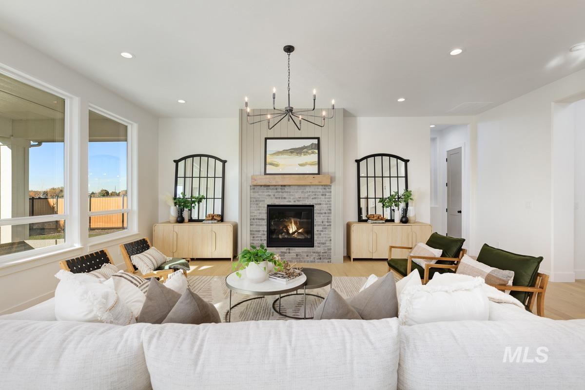 Living area with a chandelier, recessed lighting, a brick fireplace, and wood finished floors