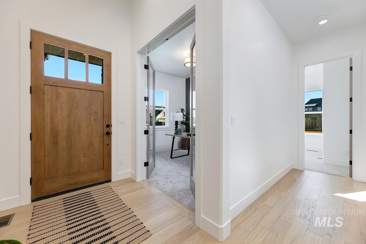 Foyer entrance with light wood finished floors and baseboards