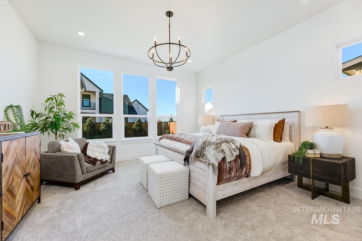 Bedroom featuring multiple windows, light carpet, recessed lighting, and a chandelier
