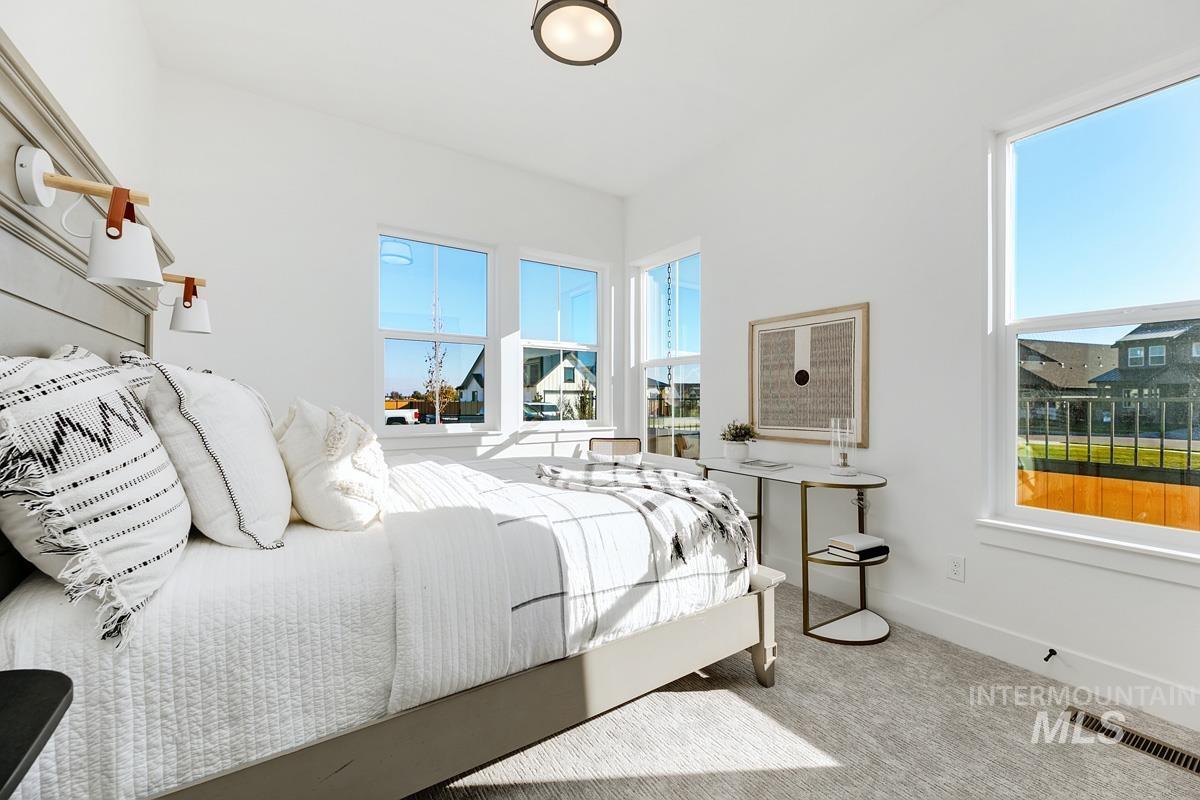 Carpeted bedroom featuring multiple windows