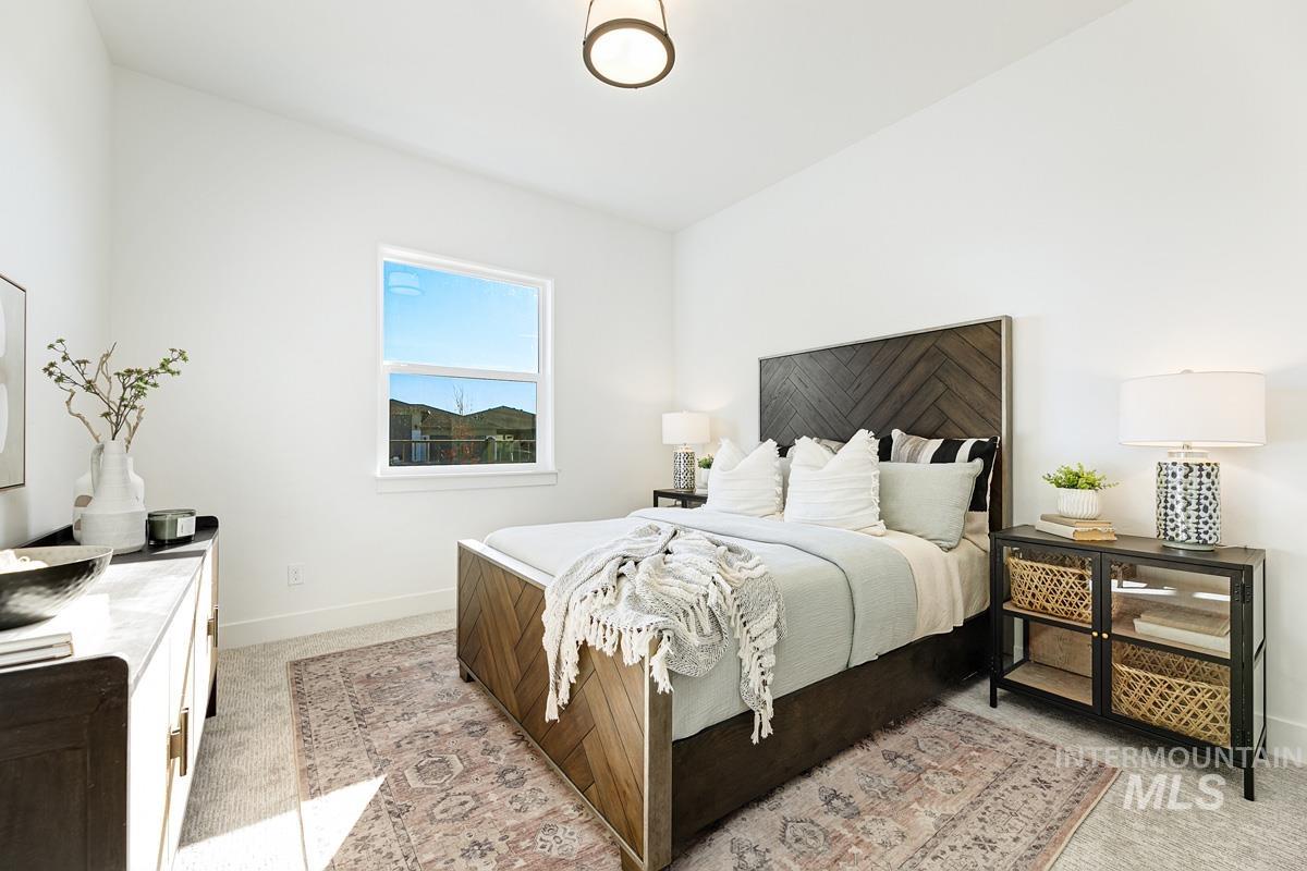 Bedroom featuring light carpet and baseboards